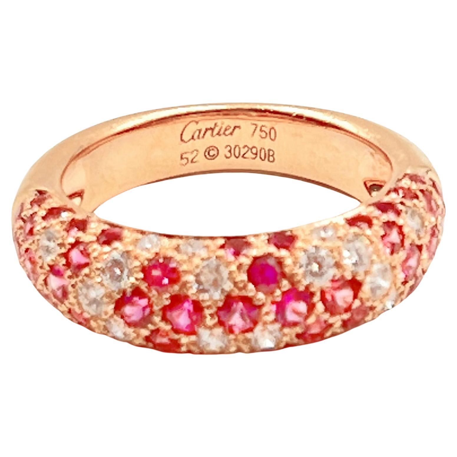 An 18k rose gold, pink sapphire and diamond domed ring by Cartier from the Etincelle collection. Pave-set with fifty round faceted pink sapphires and nineteen round brilliant-cut diamonds halfway around the band.  The diamonds have an approximate