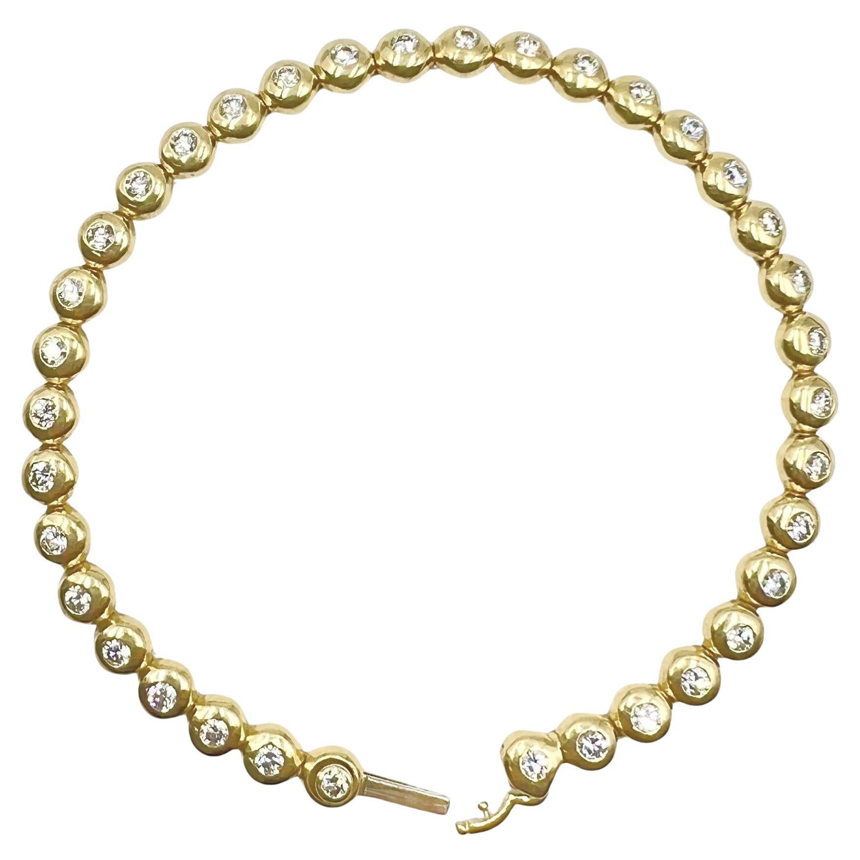 Tiffany & Co. 18k yellow gold diamond line bracelet.  Polished gold bezel links set with thirty-six round brilliant-cut diamonds weighing approximately 1.80 total carats (E-G color, VVS-VS clarity).  Hidden clasp with additional safety latch. 