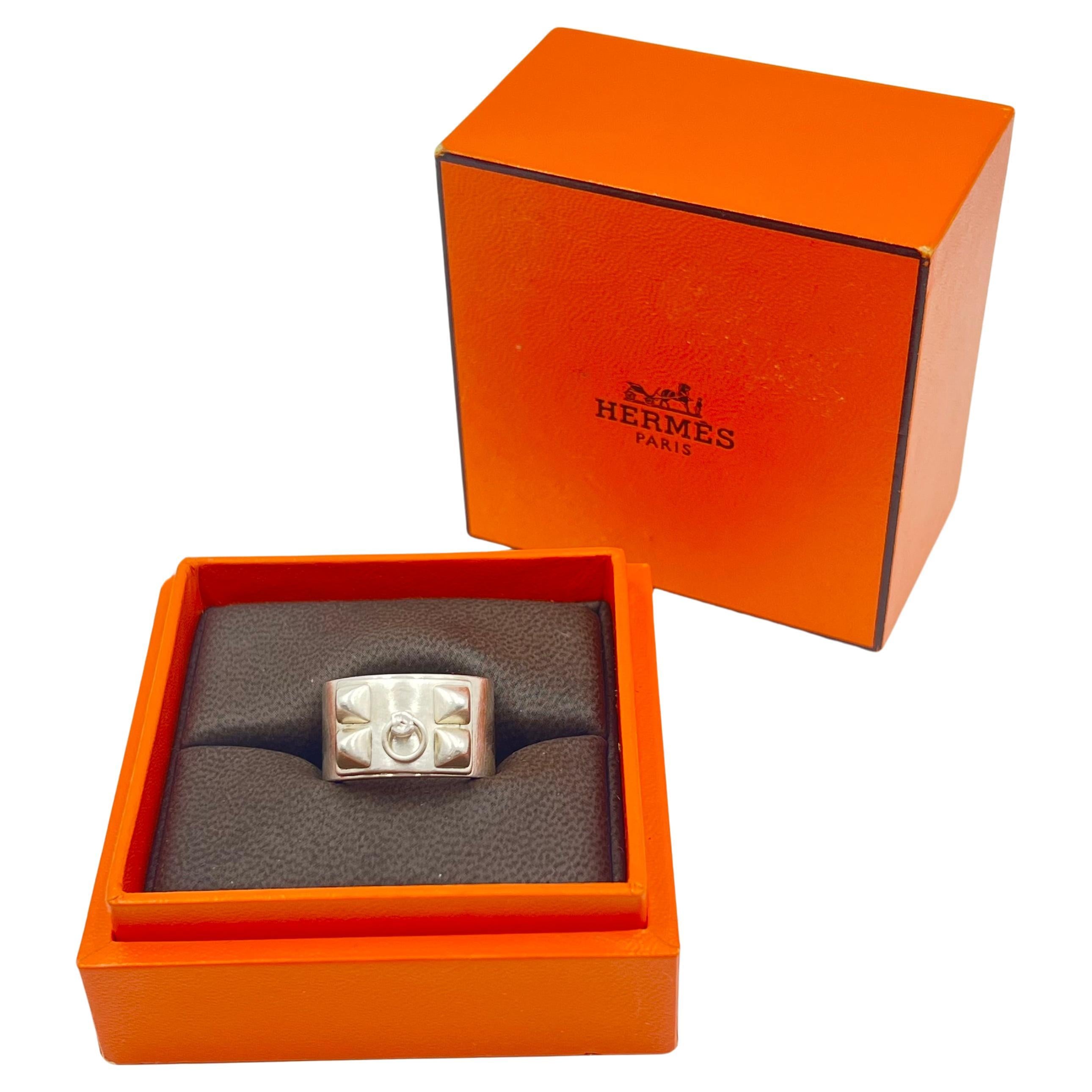 Hermès 'Collier De Chien' medium design ring.  Polished silver with bridal ring and double row of four pyramidal studs.  Signed 'HERMES' with sterling silver mark 'Ag925' '53'.  Includes orange Hermes ring box. 

In Thierry Hermès crafted a
