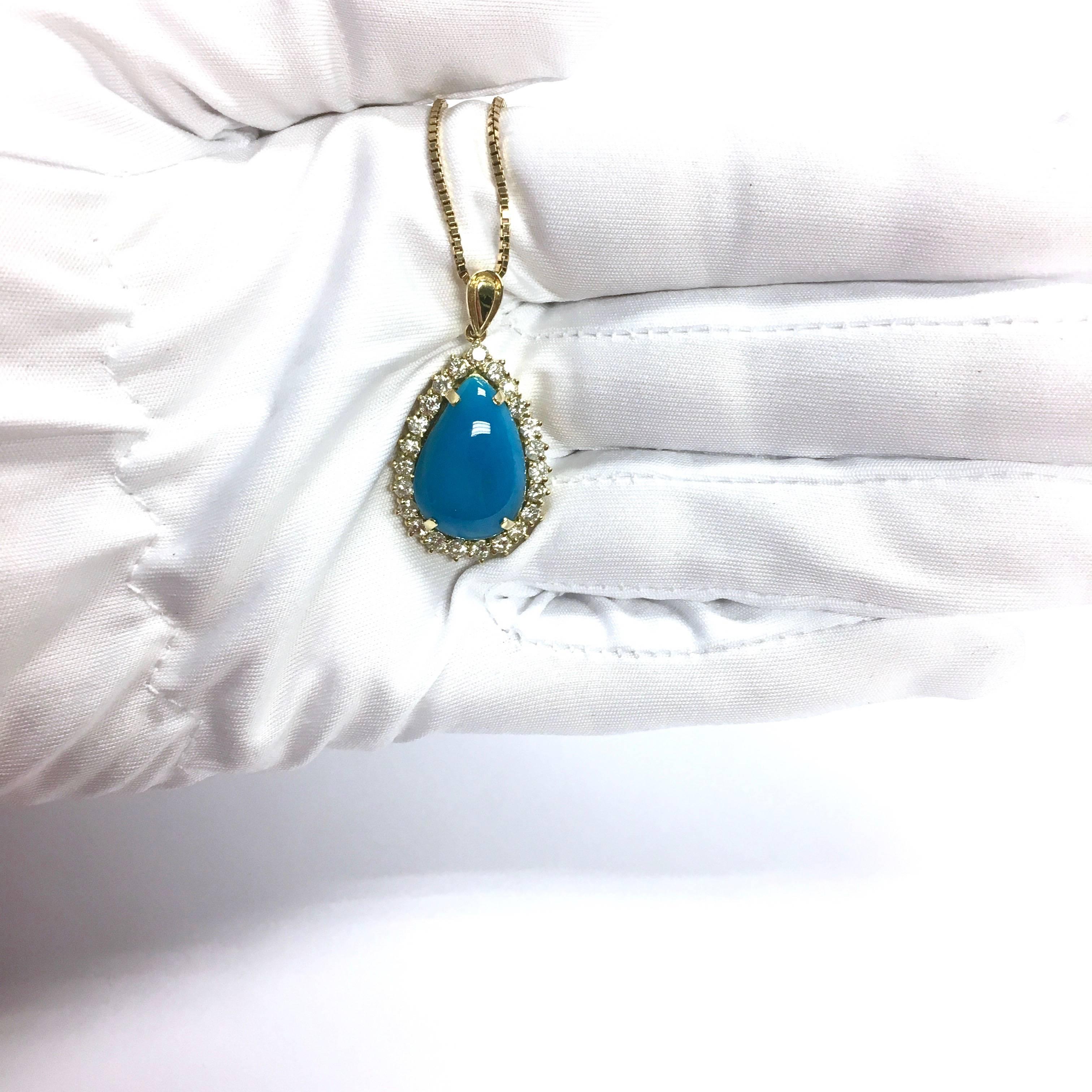Crafted in 18K yellow gold, the peandat features a 19x13x5 mm cabochon cut GIA certified natural (no treatment) turquoise, set within a bezel of round brilliant cut diamonds, supported by a gold bail and a 20 inch length box style chain terminating