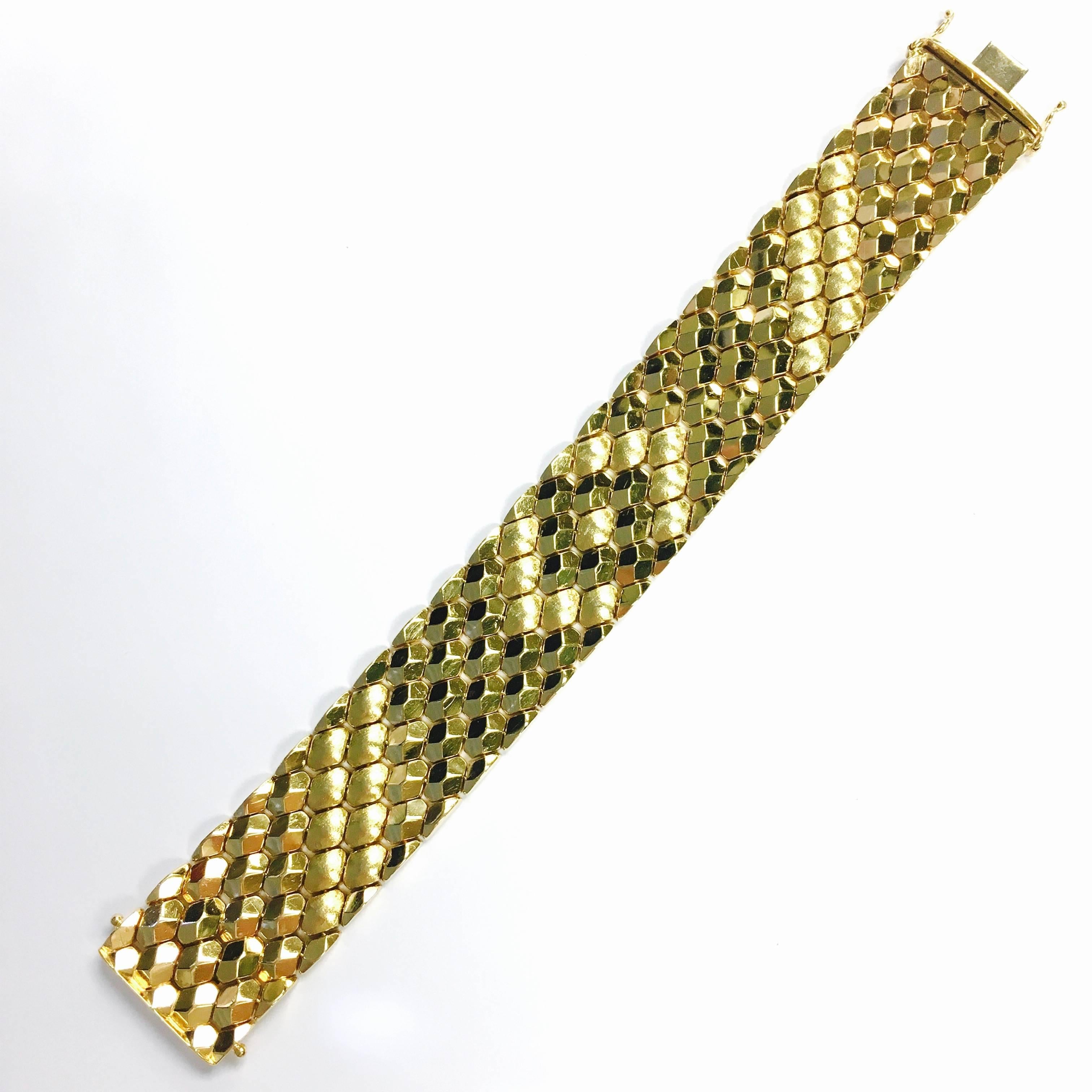 18K yellow gold 1 inch wide bracelet, featuring a honey comb design composed of polished and sating finish links. 7.5 inch length terminating in a hidden clasp with two safety eight closures. 
Weight: 60.2 grams
Marked: FOMP 750 and the factory mark
