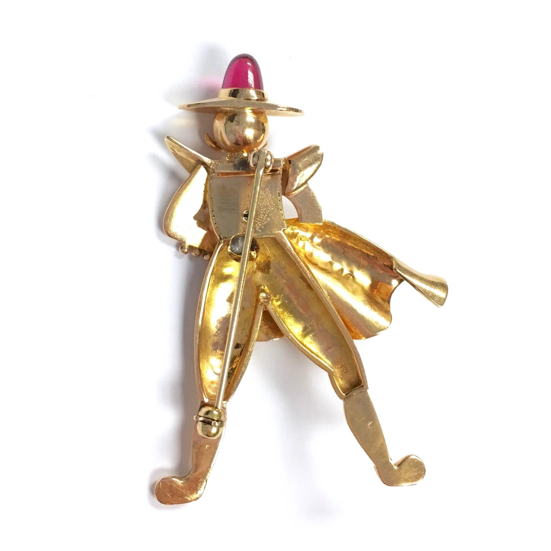 Crafted from 18K rose gold, accented by three round diamonds and a cabochon cut sythetic ruby as the top of the hat. Very unusual, almost cartoon figure-like character. Approximate total diamond weight: 0.10ct., Color: F-G Clarity: VS. Condition is