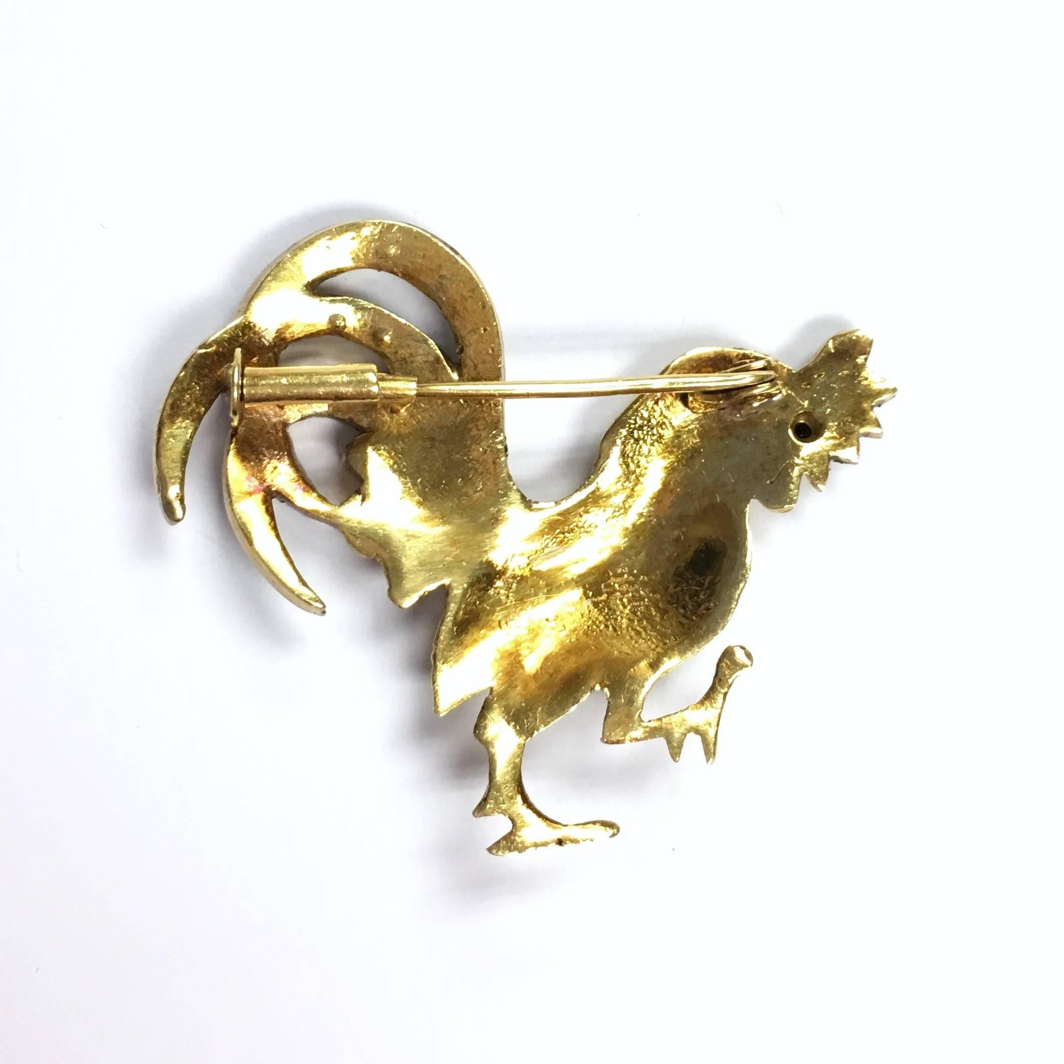 Crafted from 18K yellow gold, the crest and the tail are topped with rose cut diamond set silver, ruby set eye.
Measurements: 1 9/16" W x 1 5/16" H
Weight: 11.6 grams