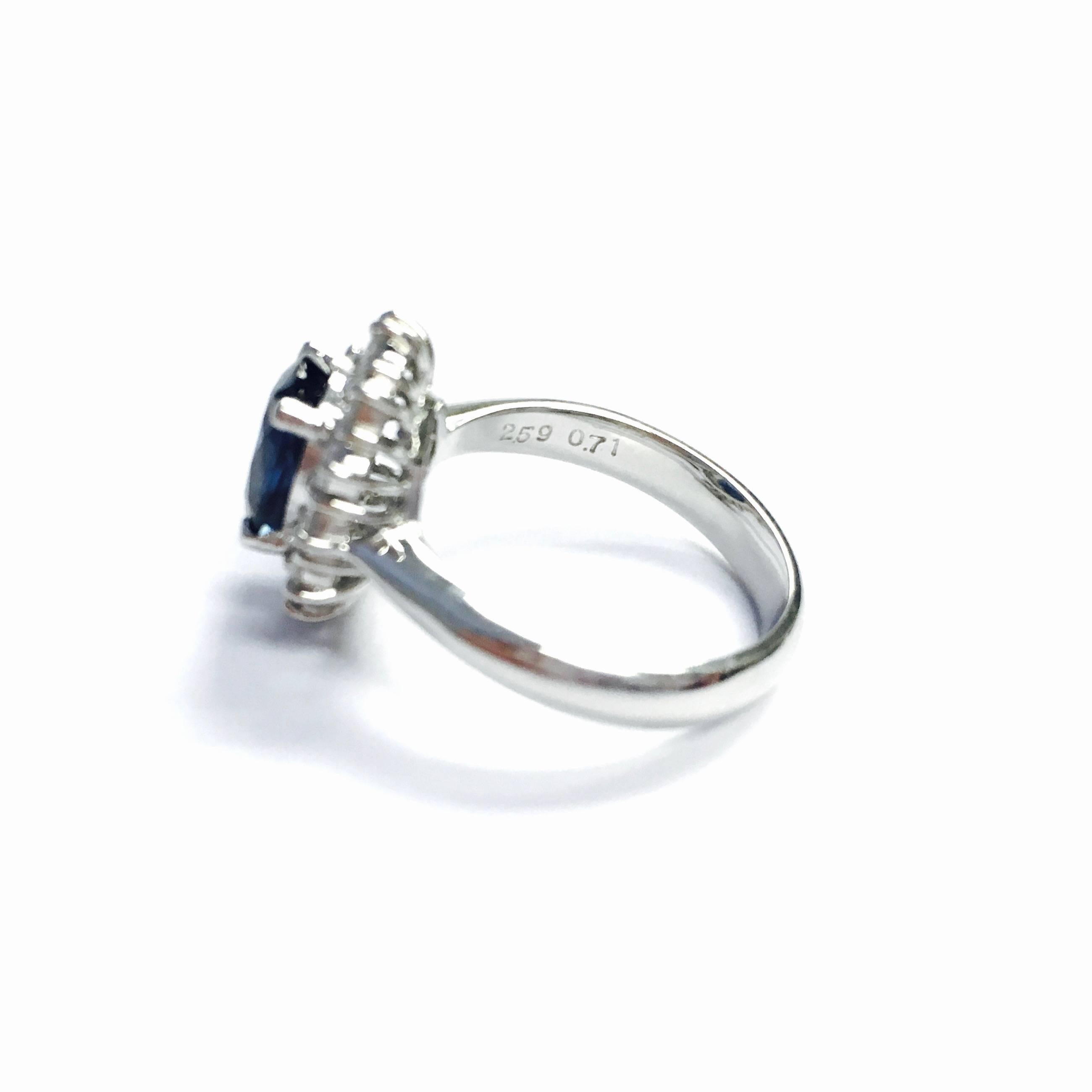 Classic style platinum ring, featuring an oval natural blue sapphire, surrounded by 12 round brilliant cut diamonds, supported by a 3.5 mm wide band. 
Sapphire: 2.59ct. No Heat. GIA Report# 2181662162
Diamond: 0.71ctw., Color: F-G, Clarity: