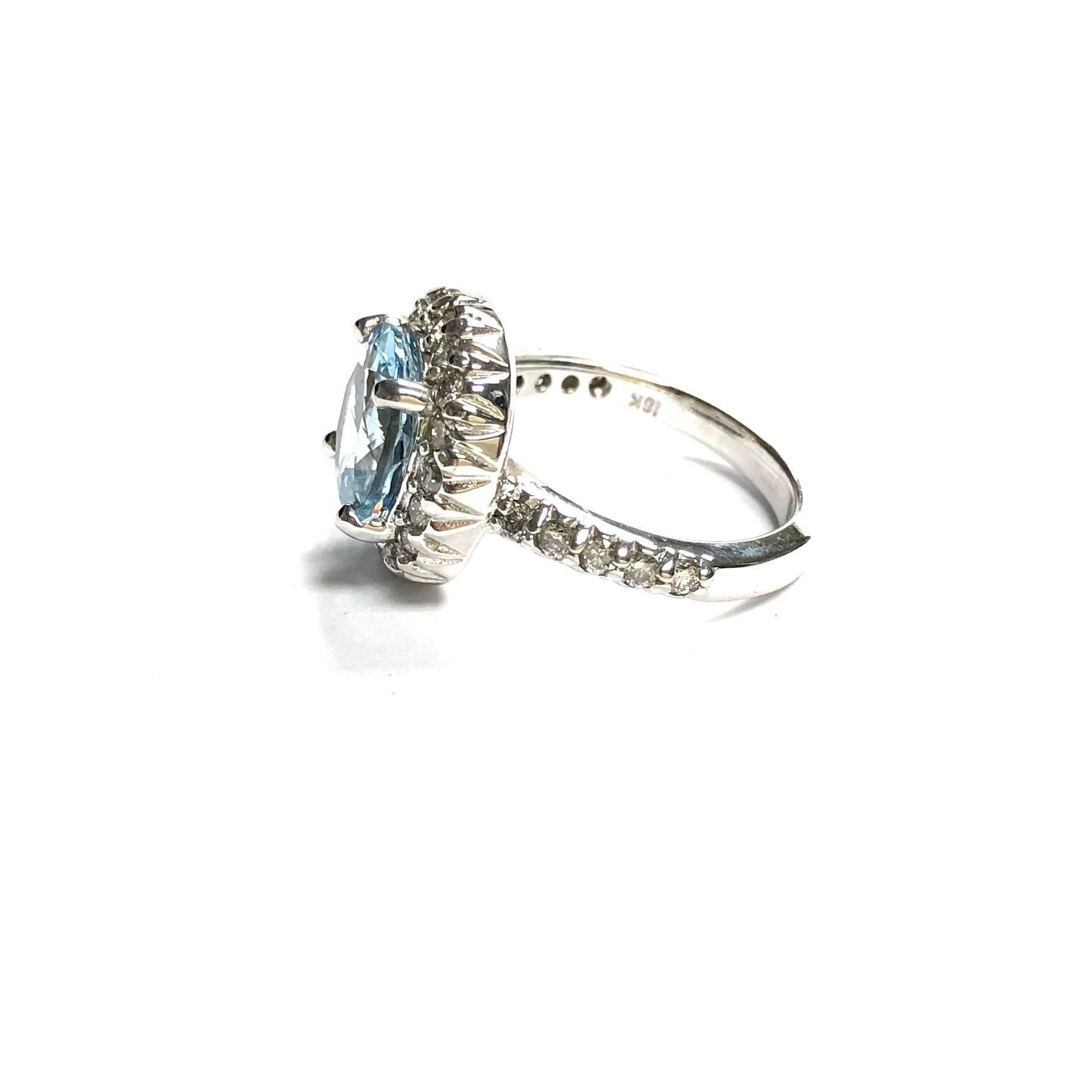 Crafted in 18K white gold, featuring a 4 carat round aquamarine solitaire set within a bezel of diamonds, supported by diamond set shoulders, completed by a three millimeter wide band. 
28 round brilliant cut diamonds, approximate total weight: