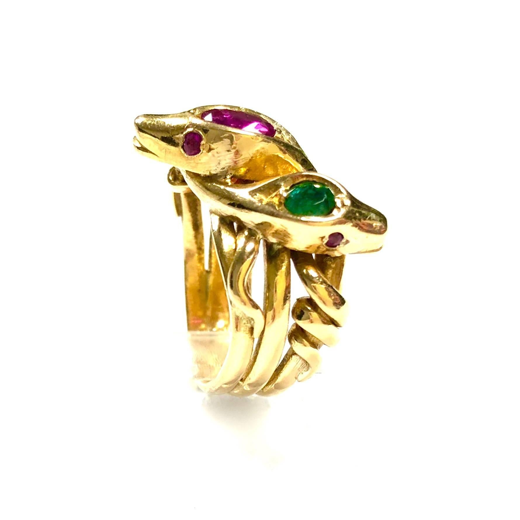 Crafted in 18K yellow gold, featuring a large snake head with natural ruby on top and ruby eyes, and two smaller heads with emerald on top and ruby eyes. 
The large oval ruby measures approx. 6.2x4.2mm. Strong, vivid color, no indication of heat
