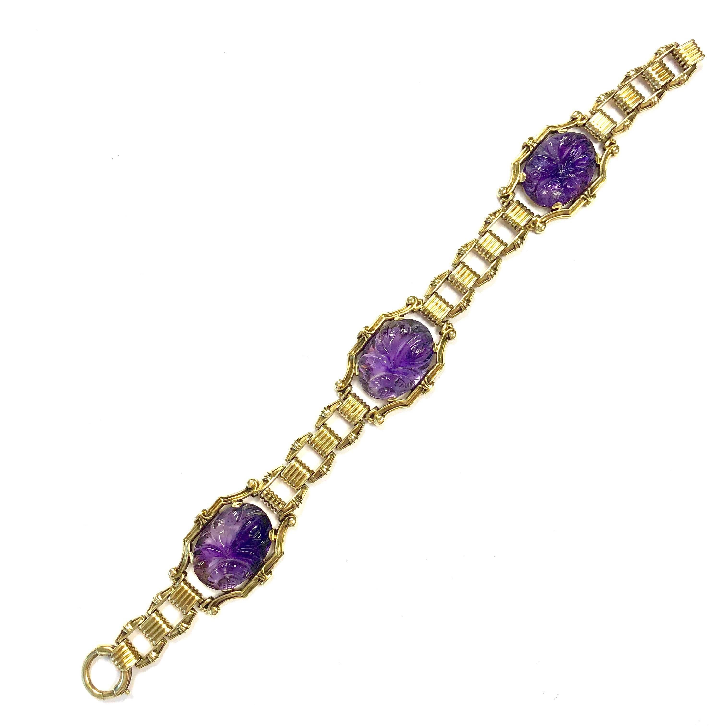 This gorgeous bracelet features three 18x13mm oval carved amethyst cabochons set within stylized gold bezels. Seven inch length terminating in a spring ring clasp. Width: 3/4