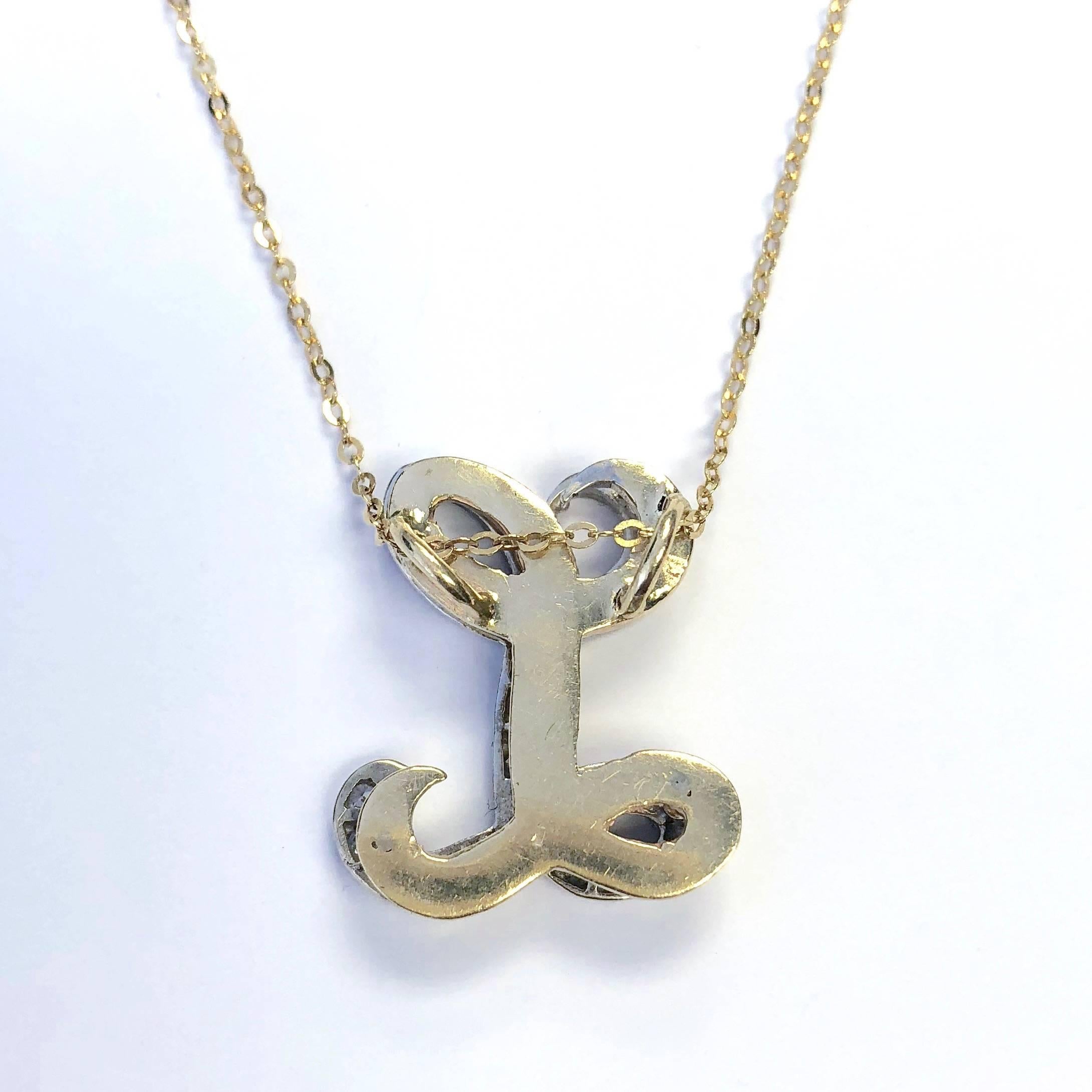 Crafted in 14K yellow and white gold, the pendant features a script letter L set with diamonds, supported by a nineteen inch length yellow gold chain.
The pendant has two levels, the top is white gold set with the diamonds and the bottom is yellow