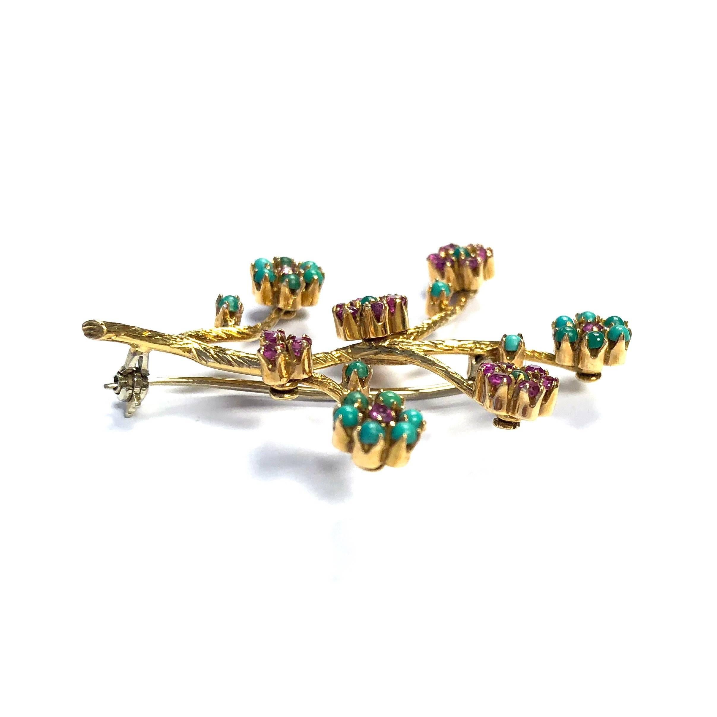 Crafted in 18K yellow gold, featuring six articulating ruby and turquoise floret clusters on gold branches. 
Measurements: 1 1/2 