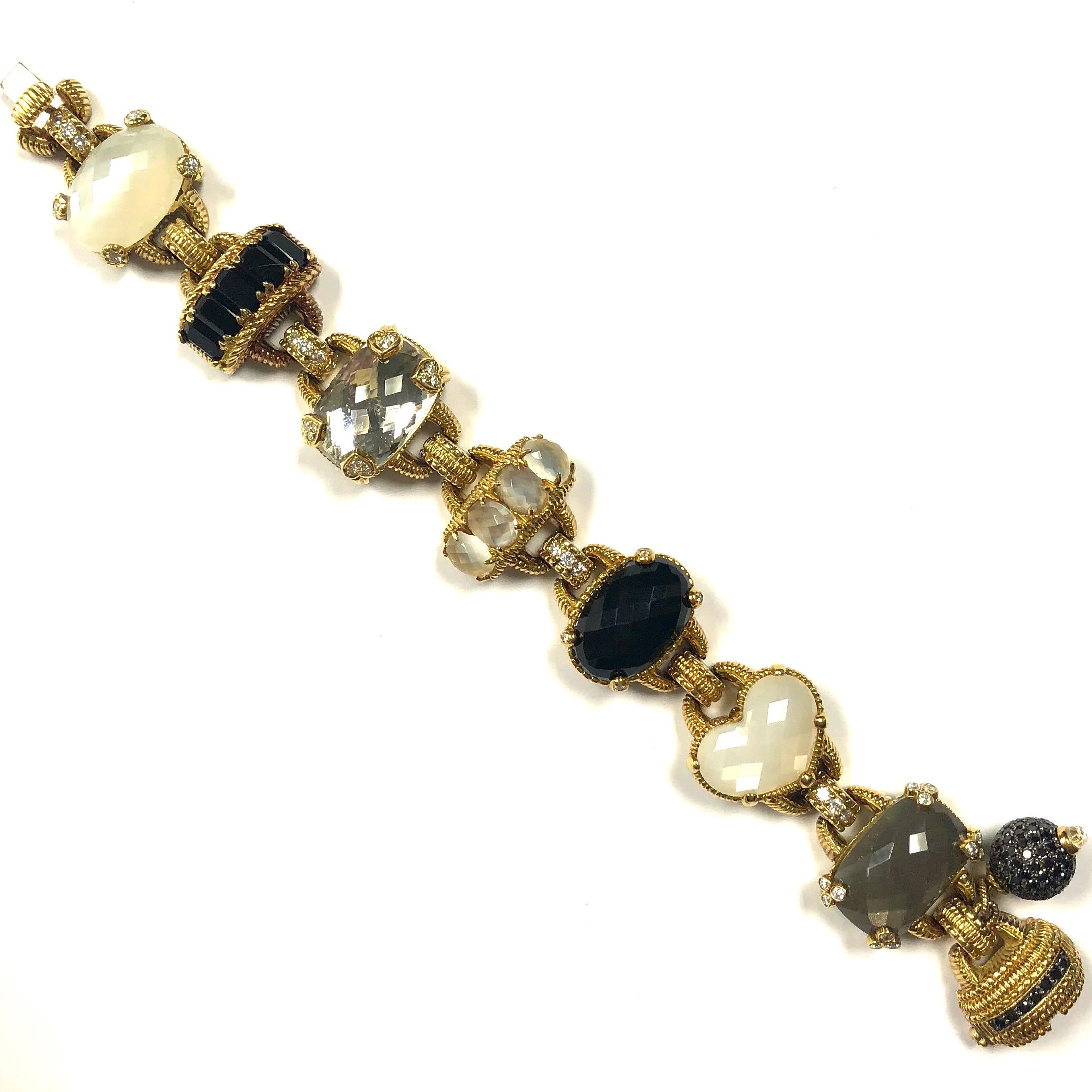 Judith Ripka 18k yellow gold Ambrosia collection bracelet with a ball charm, featuring a series of multi gemstones in various shapes and sizes, including black onyx, moonstone, rock crystal quartz and black and white diamonds. Detailed with Judith