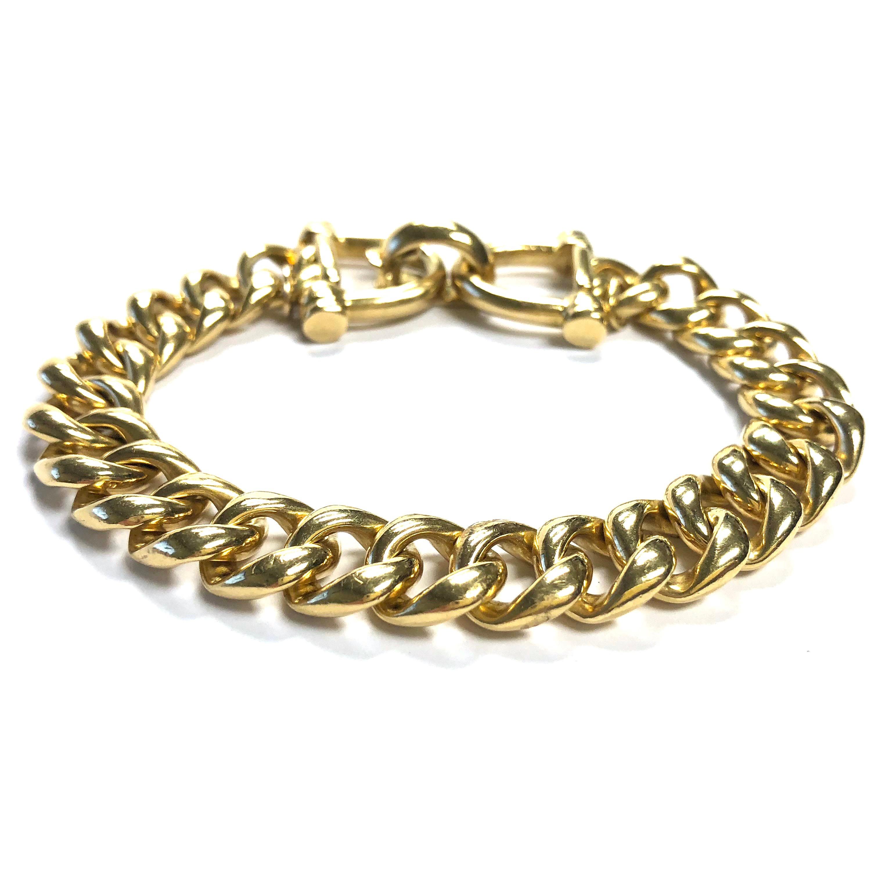 Vintage Tiffany & Co bracelet, featuring two horse bit style link at each end connected by of a series of 18K solid gold curb links. High polish finish.
Eight and one quarter inch length terminating in a fold-over clasp. Bracelet width: 7/16