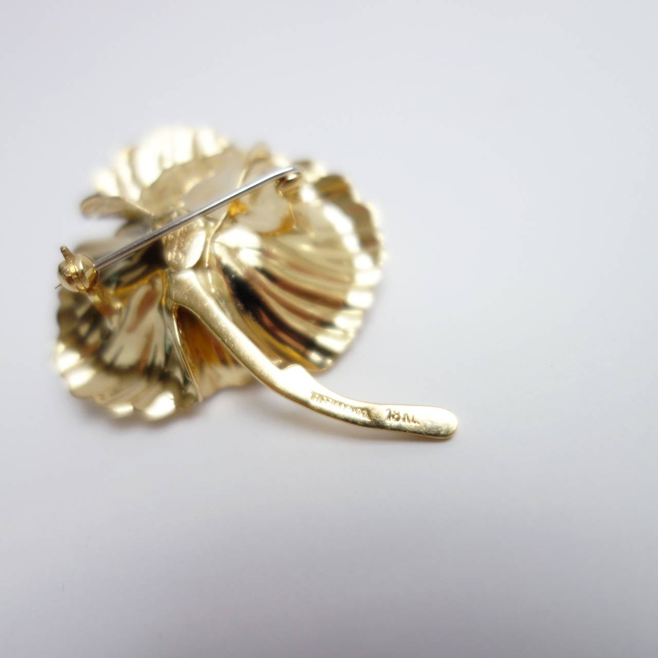 Created in 1964 by Henkel & Grosse Germany for Tiffany&Co. 18K yellow gold modernist flower pin with barked and polished finish. 

Hight: 43mm or 1 7/8 inches
Width: 36mm or 1 7/16 inches
Weight: 16.5 grams
Tested: 18k
Stamped: TIFFANY&CO. 18k