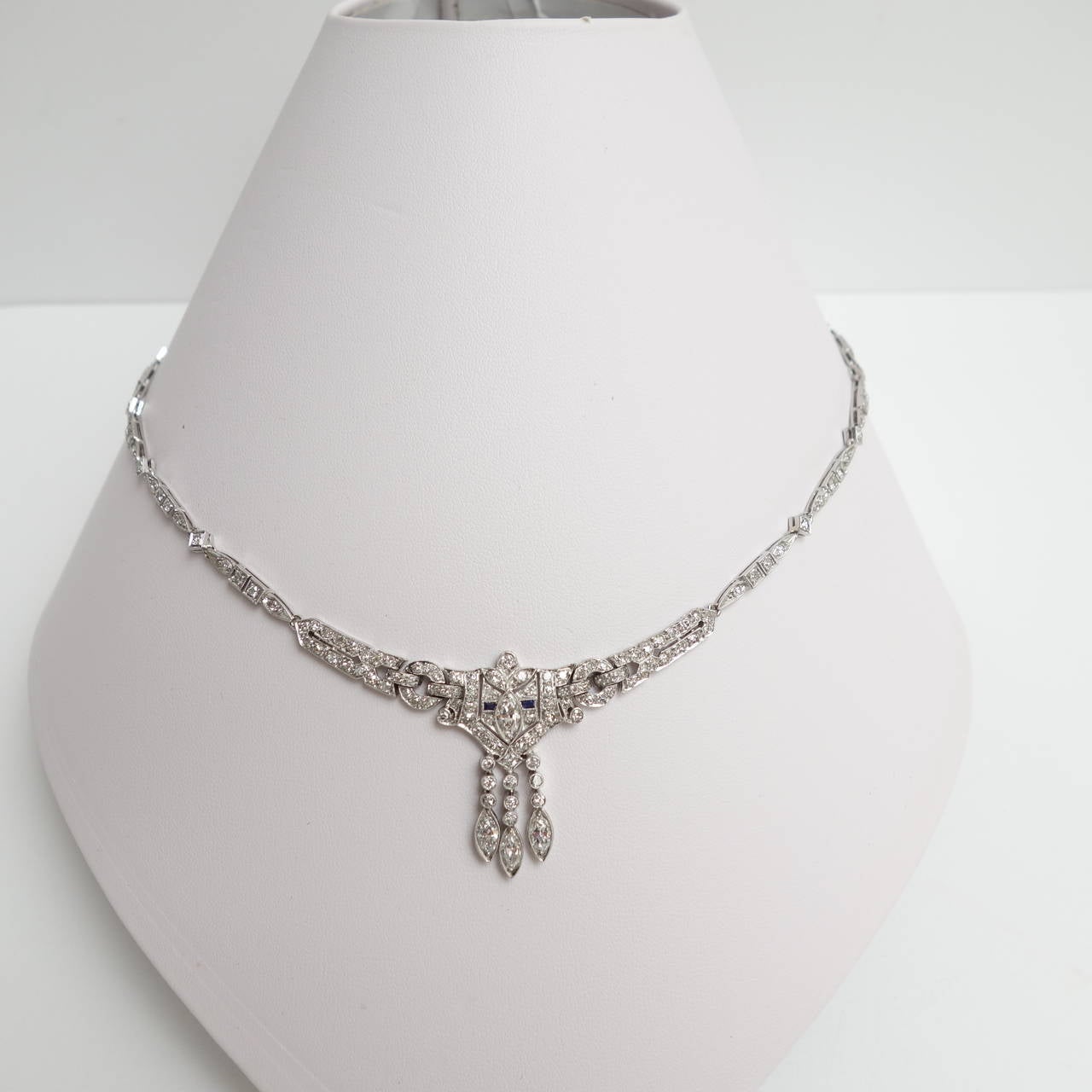 Classic elegant necklace from the Art Deco period, featuring  a diamond triple fringe center piece accented by blue sapphires,  supported by flexible diamond set links.  Total diamond weight is approximately 6.0 carats, color: G-H & H-I, clarity: