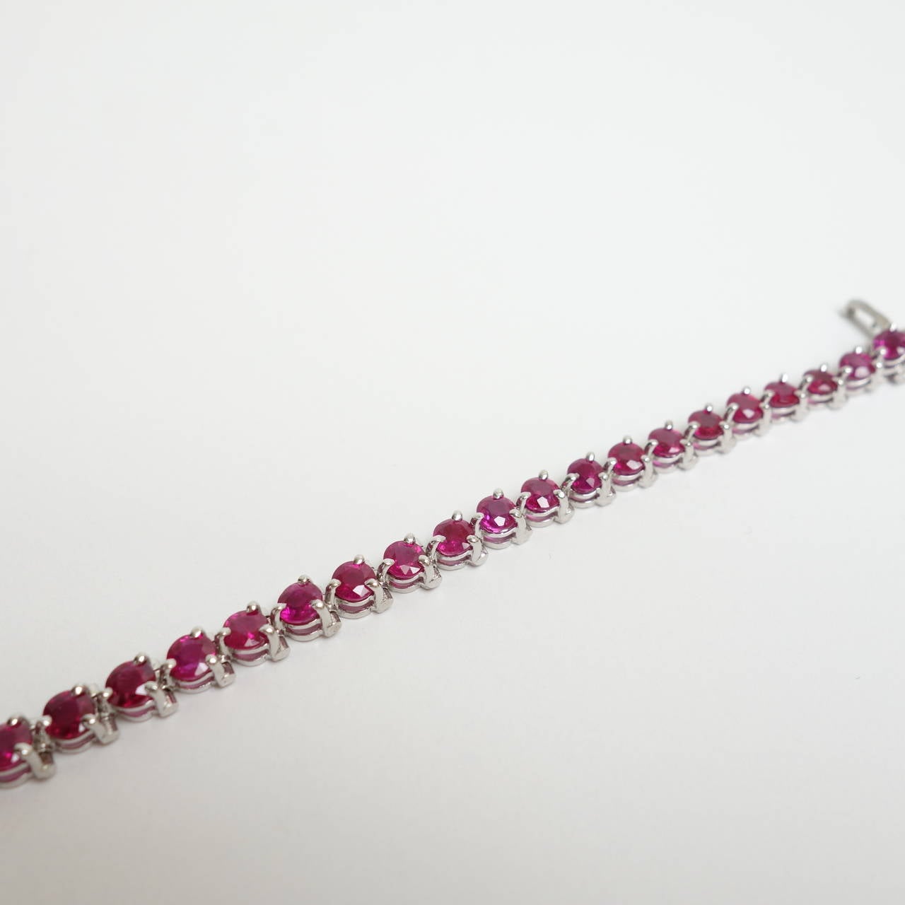Composed of a series of perfectly matched 3-prong set in-line round cut natural rubies. Vibrant, strong, saturated color, transparency and high clarity makes this simple but classic bracelet unique and desirable.  Seven inch length terminating in a