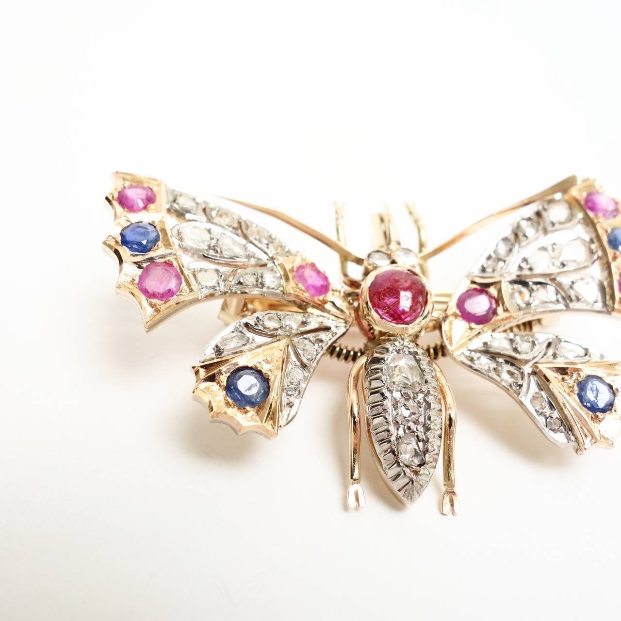 A beautiful large Ruby, Sapphire and Diamond Butterfly with articulated wings, set with an approx. 0.75ct cabochon ruby and six round cut rubies, approx. total weight od 1.00 ct,  four round cut blue sapphires approx. total weight of 0.60 ct and