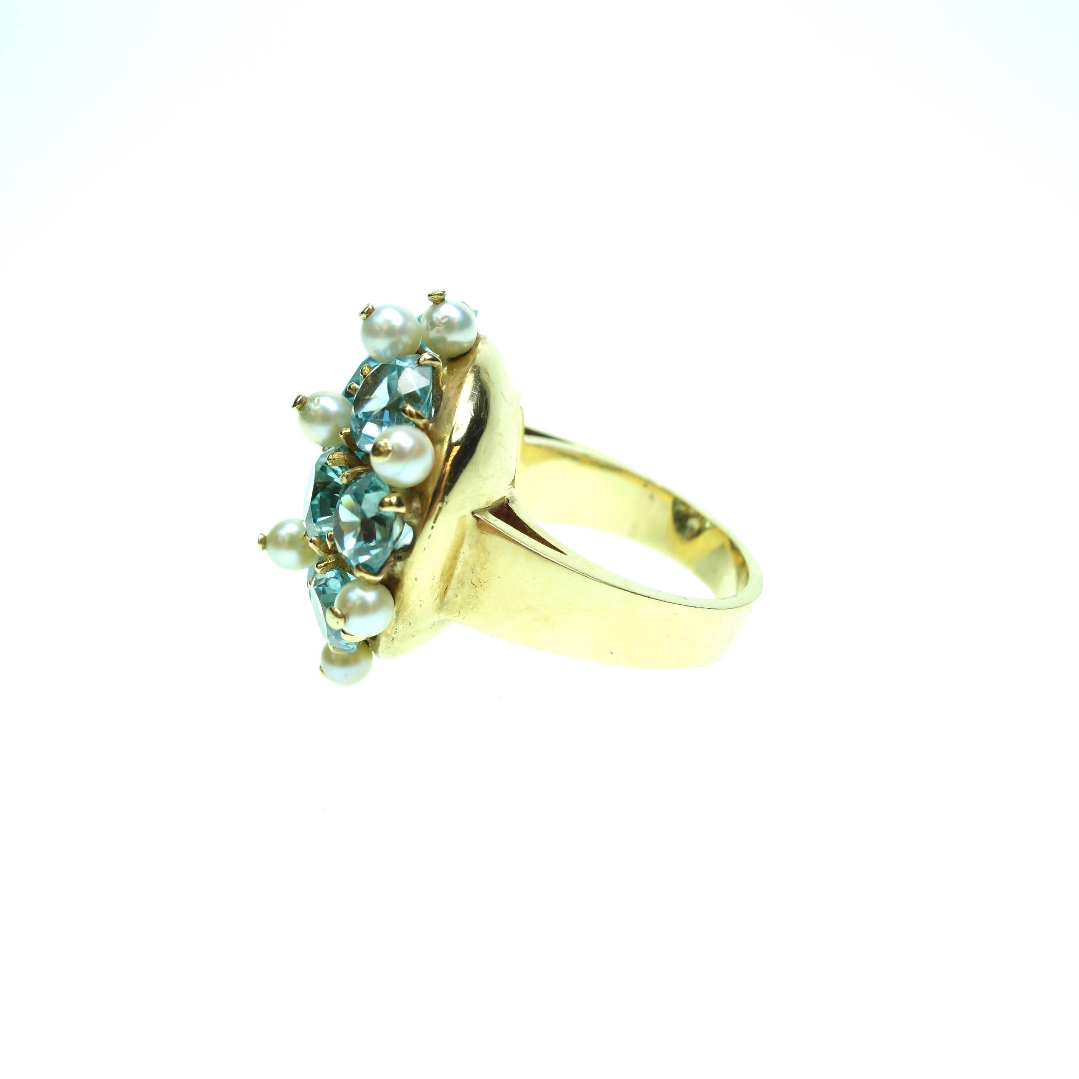 This unique 14K gold Blue Zircon and Pearl cocktail dinner ring showcases that phenomenal zircon flash and sparkle. The head of this cluster measures 23 mm  in diameter.  The blue zircons are interspersed with twelve 3.5mm pearls. The yellow shank