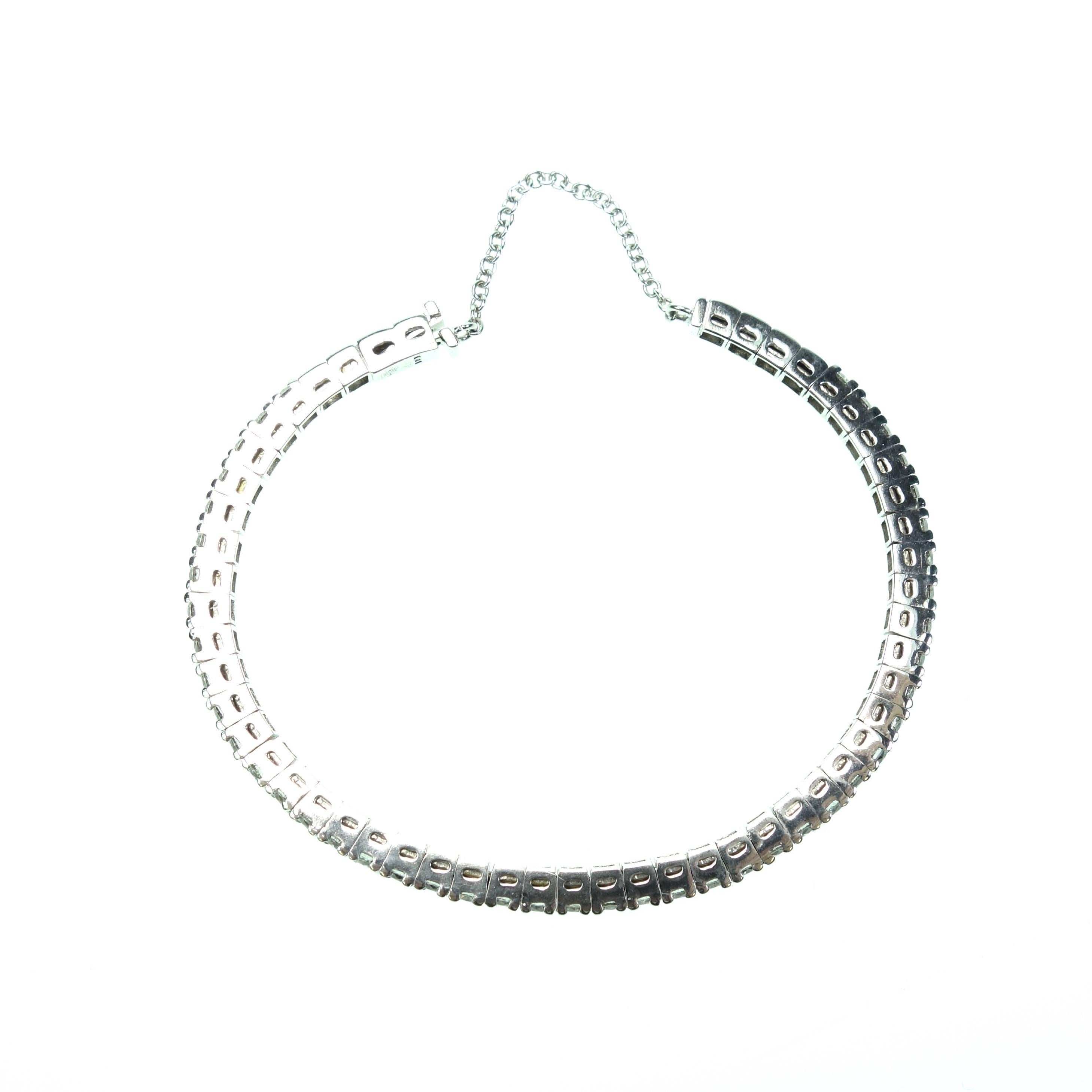 This is not your traditional diamond tennis bracelet. Set in 18K white gold the forty-five in-line set round brilliant cut diamonds create a tennis bracelet look with a cuff bracelet design. There is a safety chain connecting the two ends of the