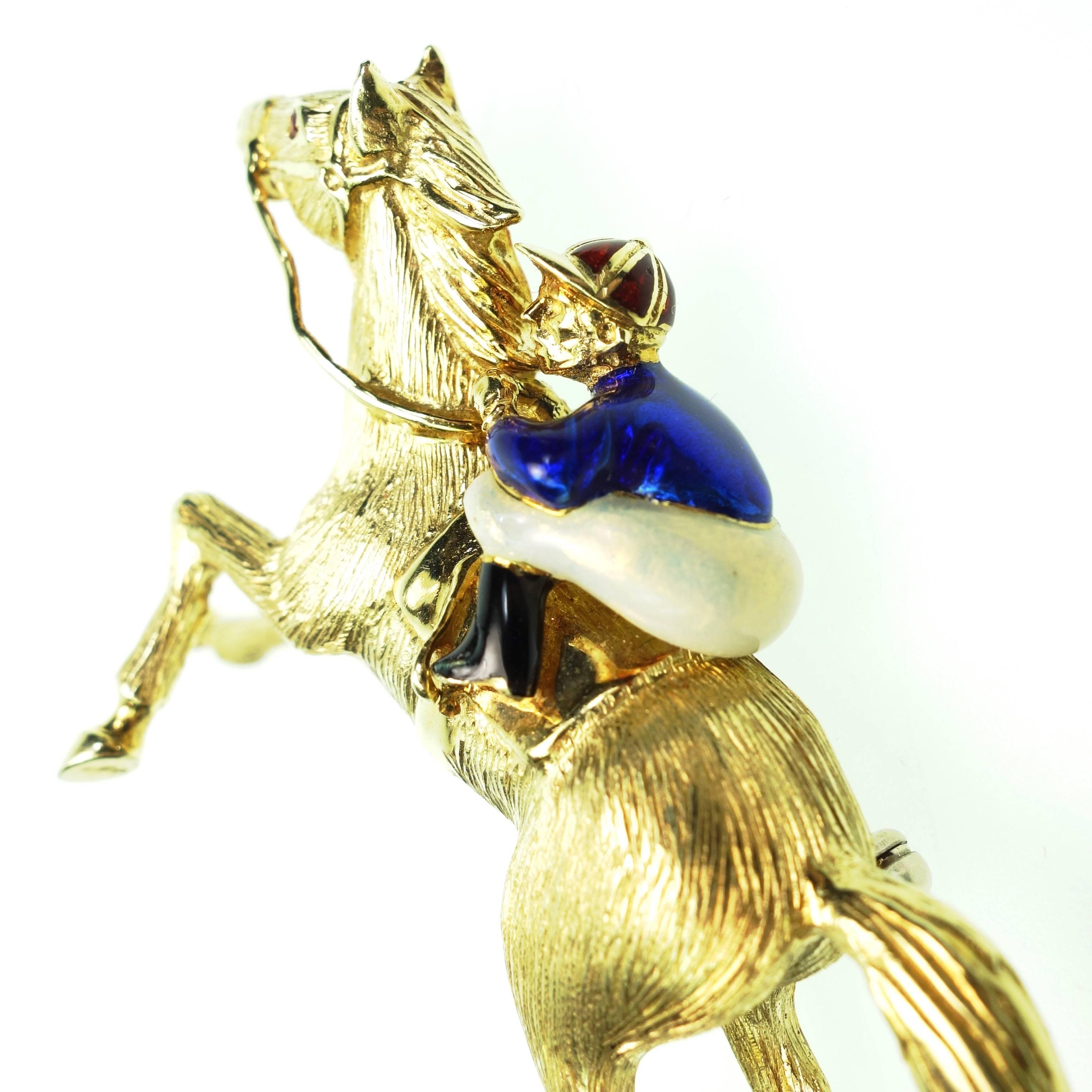 Fantastic 18K yellow gold race horse with jockey, accented with blue and white enamel and a ruby eye. Bright polish and textured finish.
Measurements:
2.25" L x 1.5" H x 0.75" D
Weight: 30.9 grams