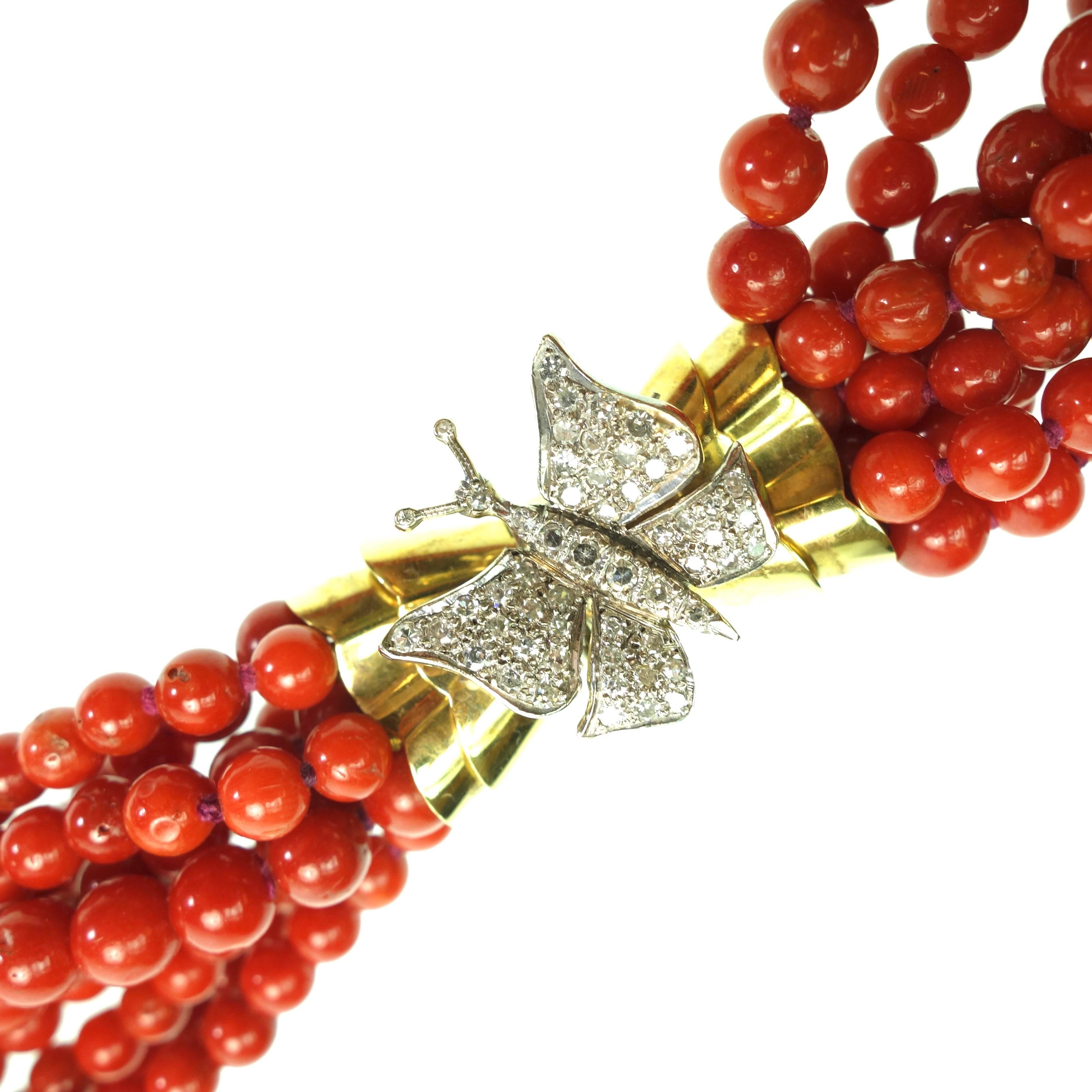 Gorgeous multi strand coral bead necklace in 30 inch opera length. There are nine strands of natural red coral beads terminating in an 18K yellow and white gold diamond set butterfly station. The beads measure from 4.5mm up to 6mm in diameter.