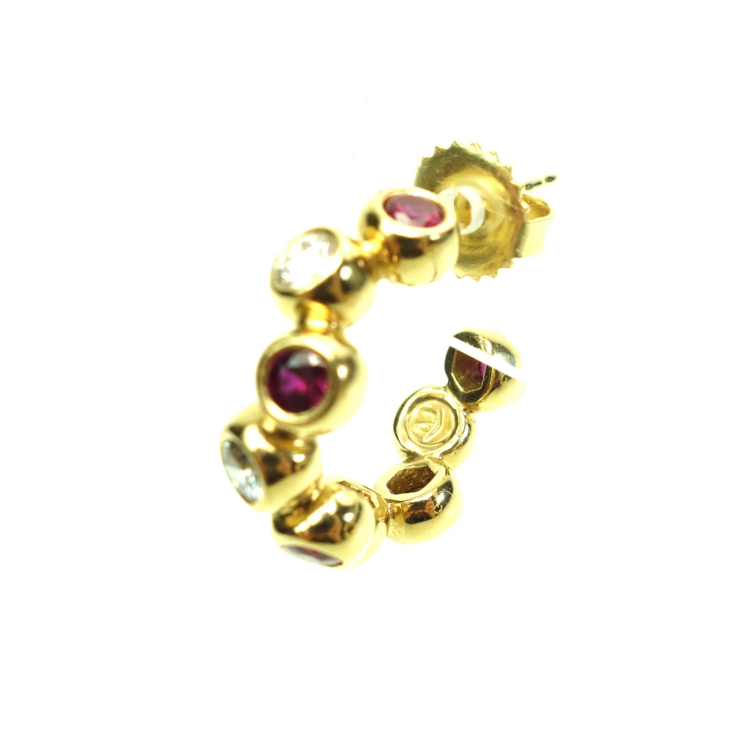 Amazing 18K yellow gold ruby and diamond hoop earrings by Movado. Rare.
Each earring features nine alternating round rubies and diamonds individually set in wide gold bezels. The bezels are off-set, creating a slightly zigzagging design. 
8