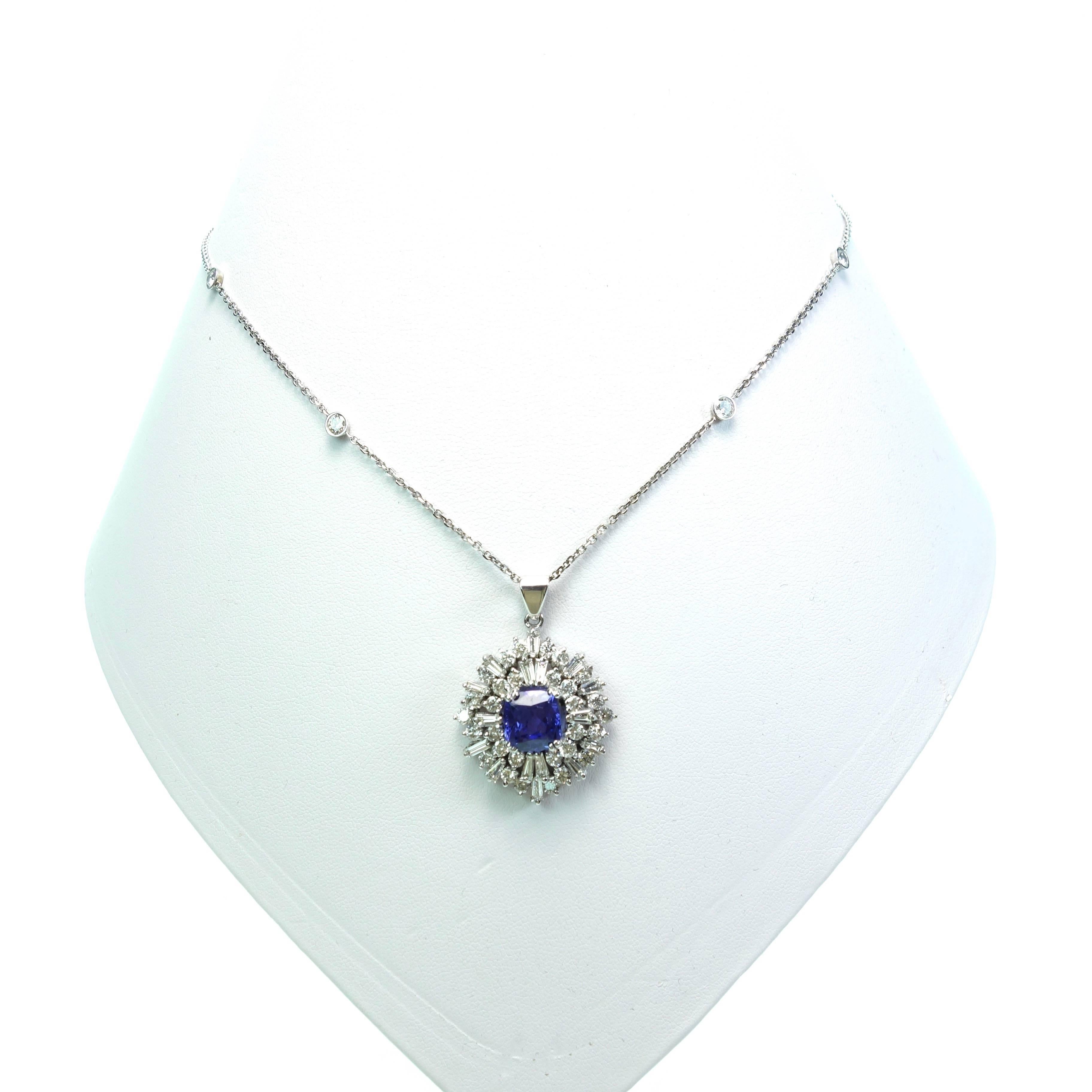 14KT white gold Tanzanite and Diamond pendant, featuring a cushion shaped Tanzanite solitaire approx. weight of 2.50ct, surrounded by 16 tapered baguette and 30 round brilliant cut diamonds. The approximate total weight of the diamonds is 3.60ct.