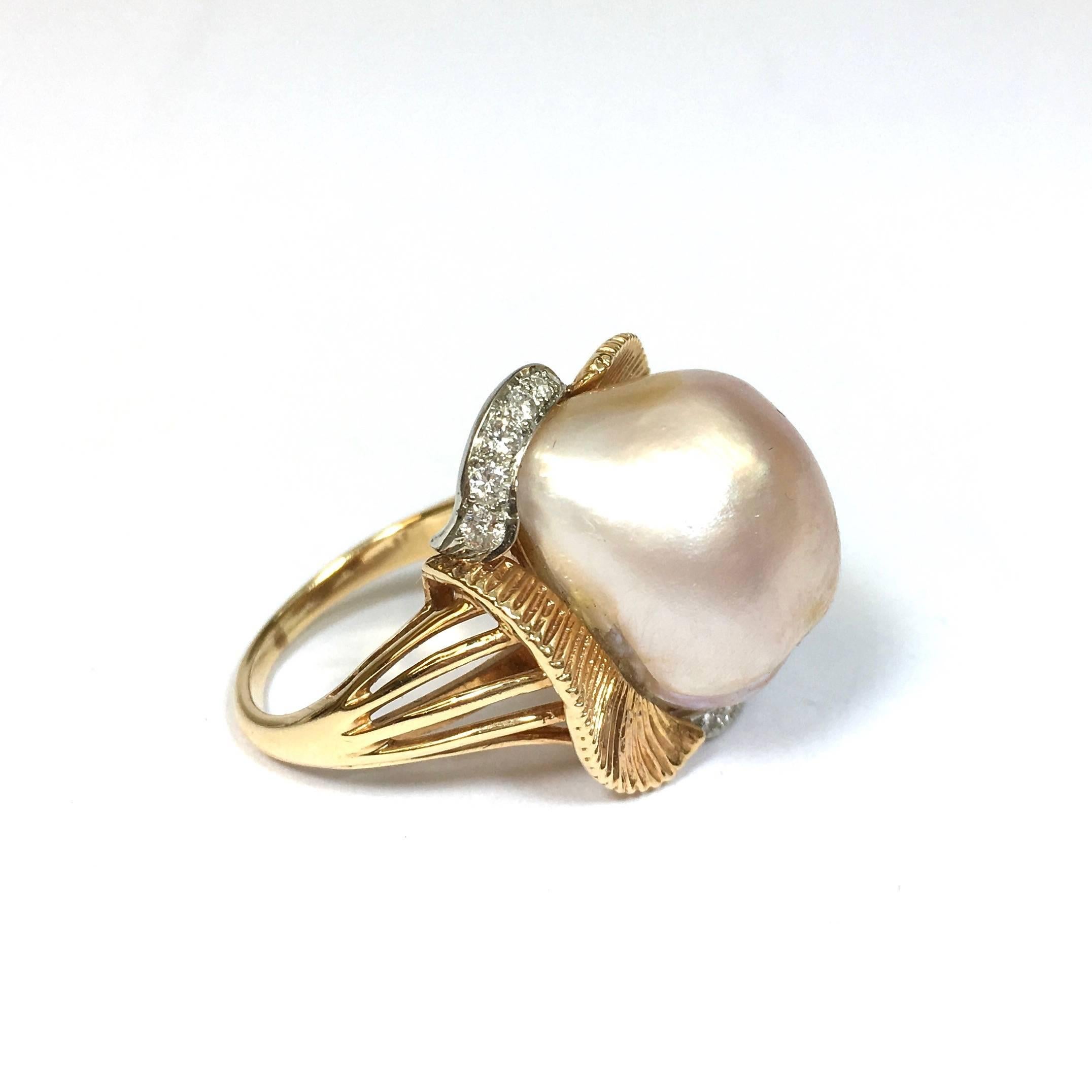 Freestyle fabulousness by American jewelry designer, William Ruser. Textured gold and diamond set platinum ribbons in an organic asymmetrical design featuring a peachy pink American Freshwater pearl with a luscious luster.

HALLMARKS: