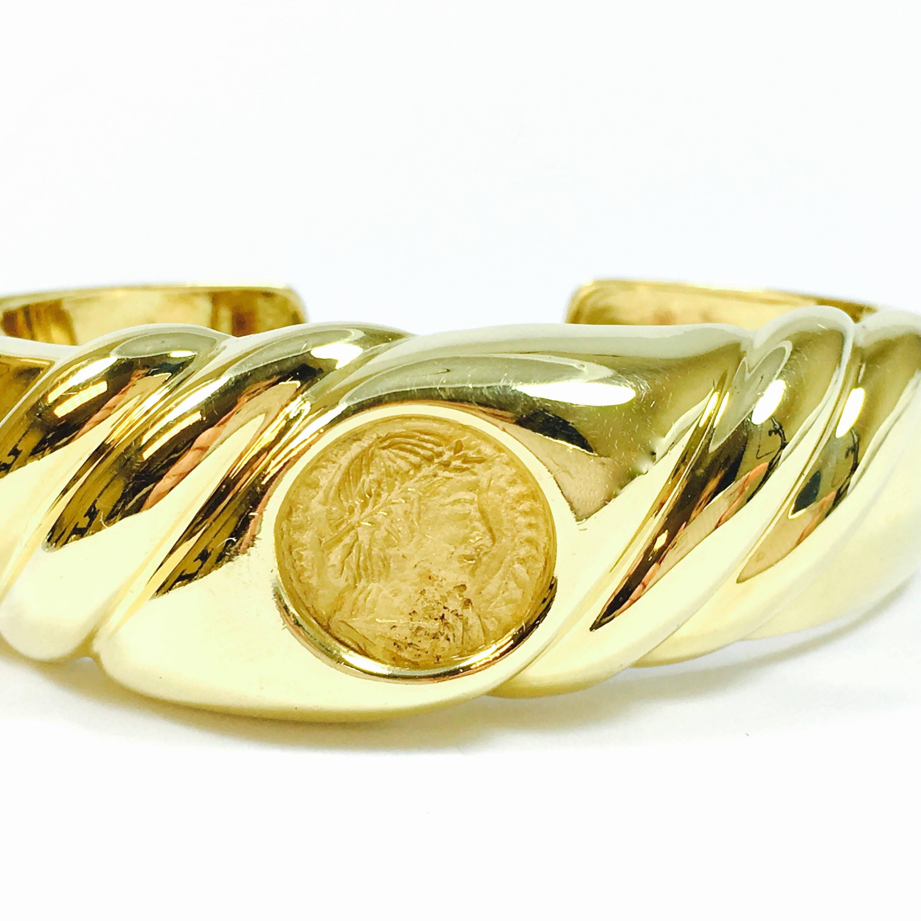 Heavy 18K yellow gold double hinged bangle bracelet, featuring a 14 mm round roman gold coin set in the center of the  21 mm wide front section, tapering down to 8 mm on the back. The bracelet opens up on both sides for easier access.
Fits up to a 6