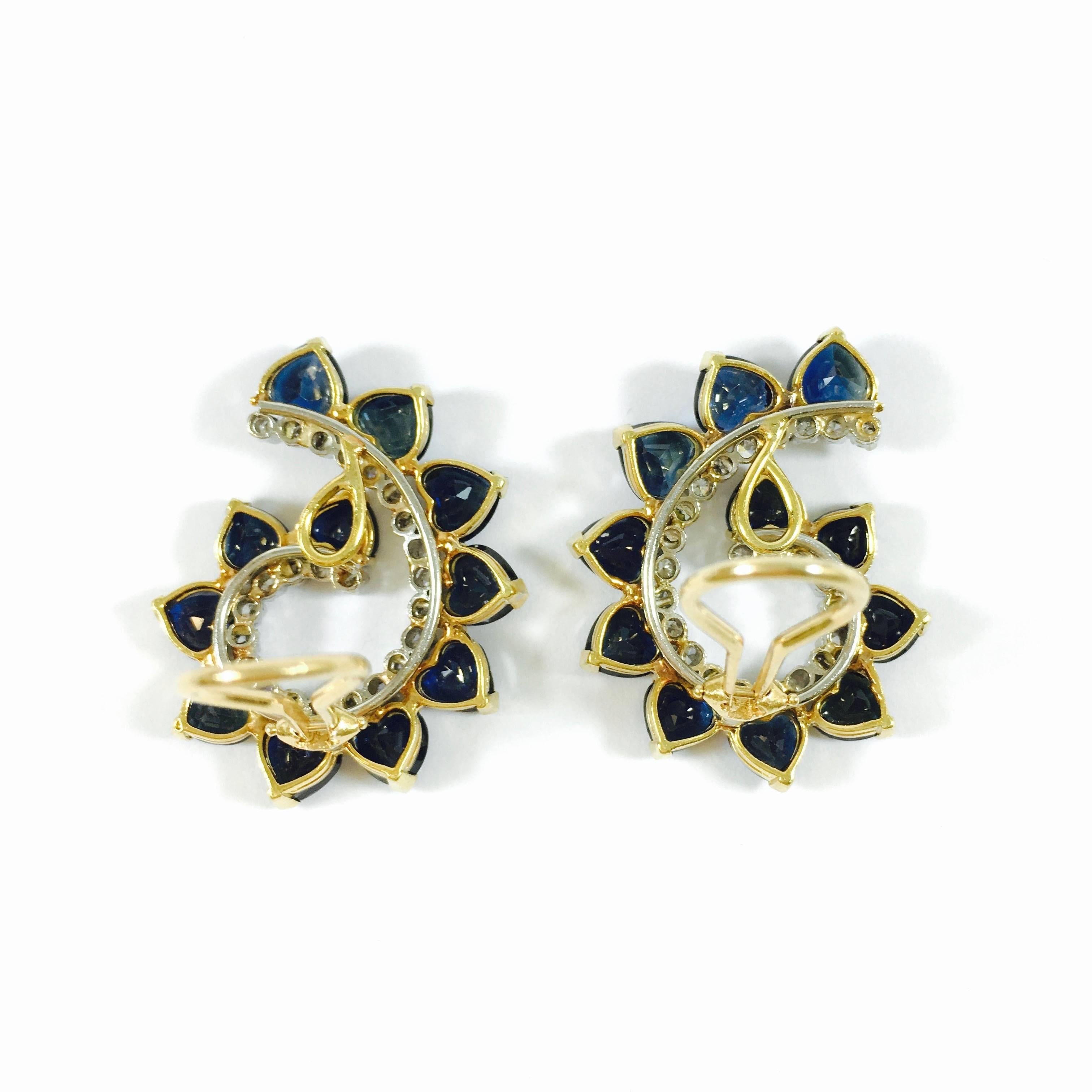 Crafted from 14K yellow and white gold, each earring features a series of 11 graduating heart shaped sapphires, and 24 round brilliant cut diamonds set in a stylized swirl design. 
22 sapphires: approx. total weight of 11.0 ct
48 diamonds: approx.