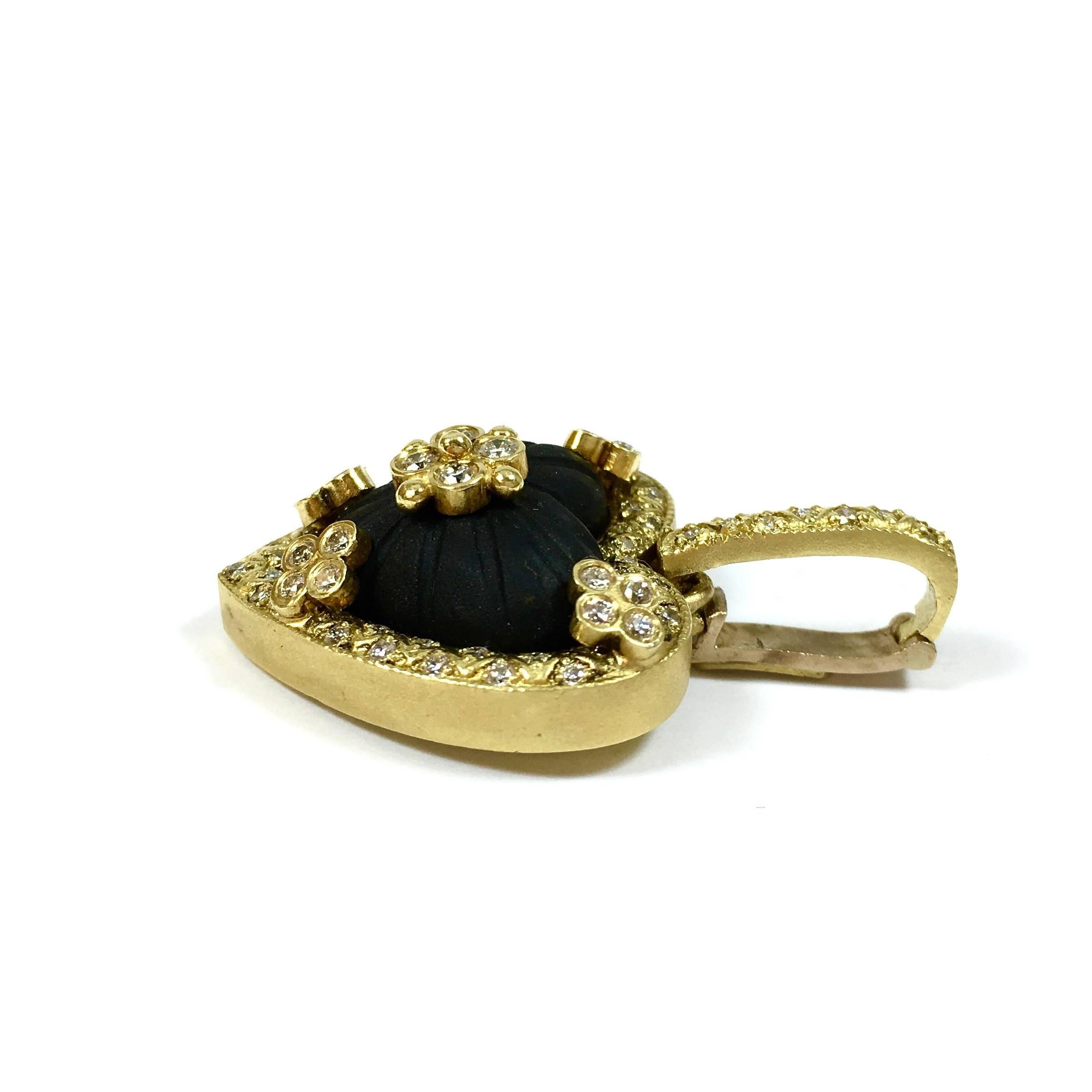Gorgeous 18K yellow gold pendant enhancer, set with a special cut, heart shaped frosted black Onyx in the center, encrusted with 1.00 carats of diamonds. Color: G, Clarity: VS
The pendant measures 1.5 inches in length (including bail) and 1.1