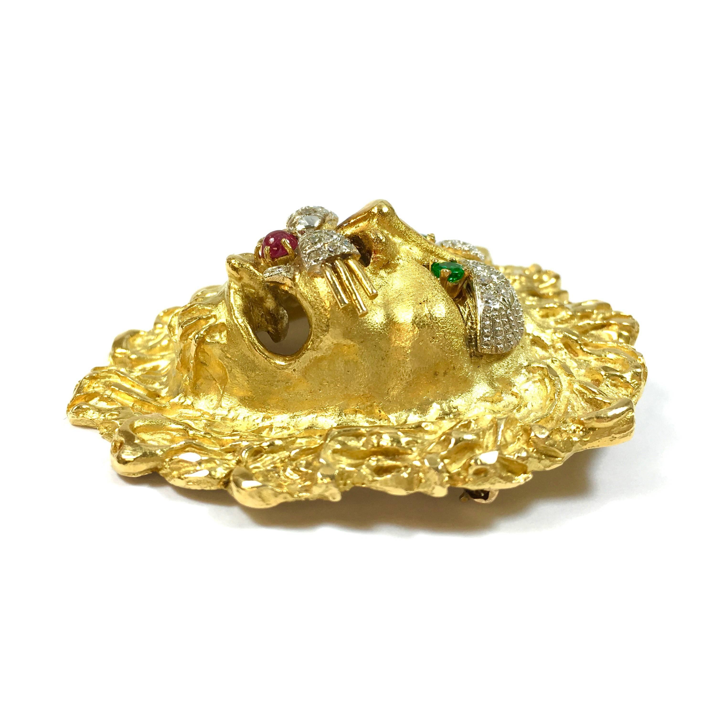 Large 18K yellow gold lion brooch pendant by Hammerman Brothers.
Set with teo round cut emeralds, a round cabochon ruby and 24 single cut diamonds.
Measurements: 2 1/2