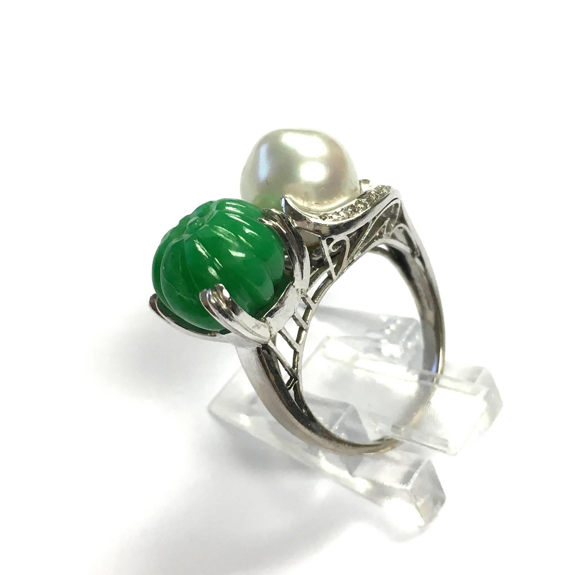 14K white gold vintage ring, featuring a hand carved approx. 10 mm wide natural jade and a 9.5 mm baroque cultured saltwater pearl accented by diamond set ribbons.
Size: 5
Weight: 7.4 grams