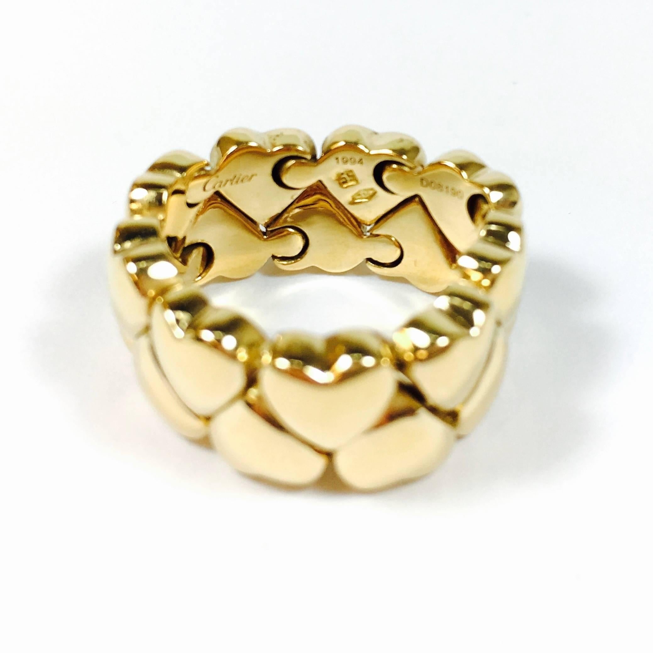 Cartier double hearts flexible ring from the Double Coeurs 1994 collection. Crafted from solid 18k yellow gold in a high polished finish. 
The band is fully signed by Cartier with the metal content and serial number.
Hallmark: Cartier 750 55