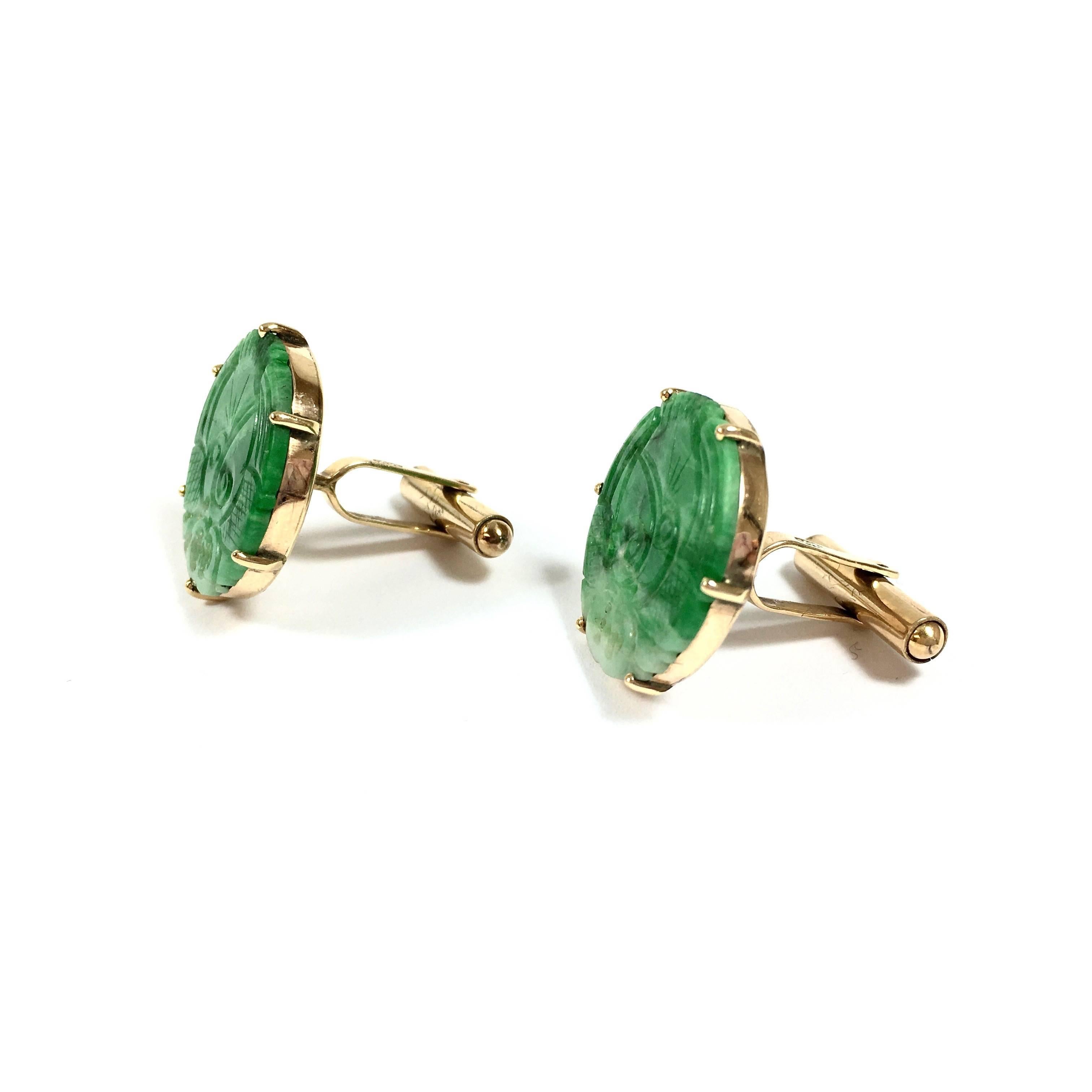 Crafted from 14K yellow gold, each cufflink features a 21 mm round hand carved  natural jade with  bird motif. 
Weight: 11.3 grams