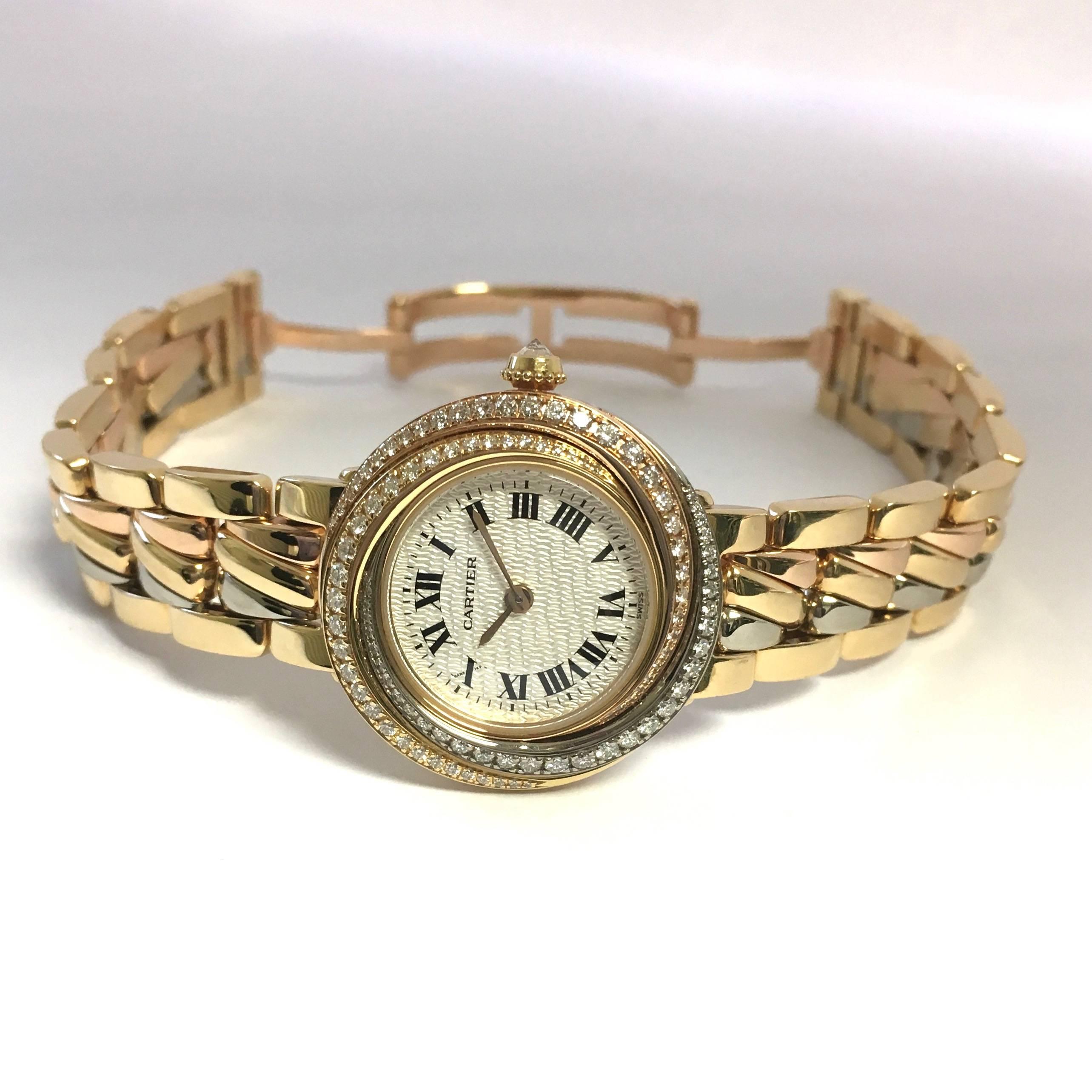 Brand new Cartier Trinity diamond watch with rare yellow, white and rose gold bracelet. 27mm Cartier Trinity watch case with swiss quartz movement, pavé set tri-color bezel with factory diamonds, sapphire crystal, white textured dial, black roman