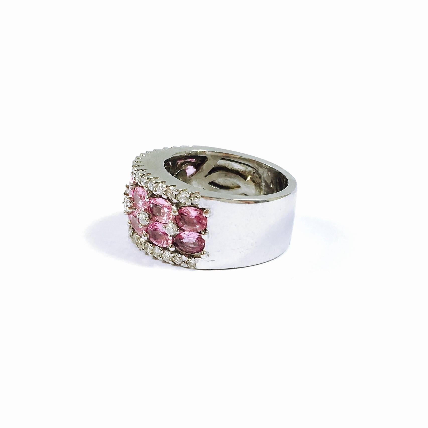 18K white gold 10mm wide band, featuring on the fron two rows of oval cut pink sapphires framed by diamonds. 
14 pink sapphire, exact total weight: 2.52ct (Stamped inside the shank.)
40 round brilliant cut diamonds, exact total weight: 0.53ct