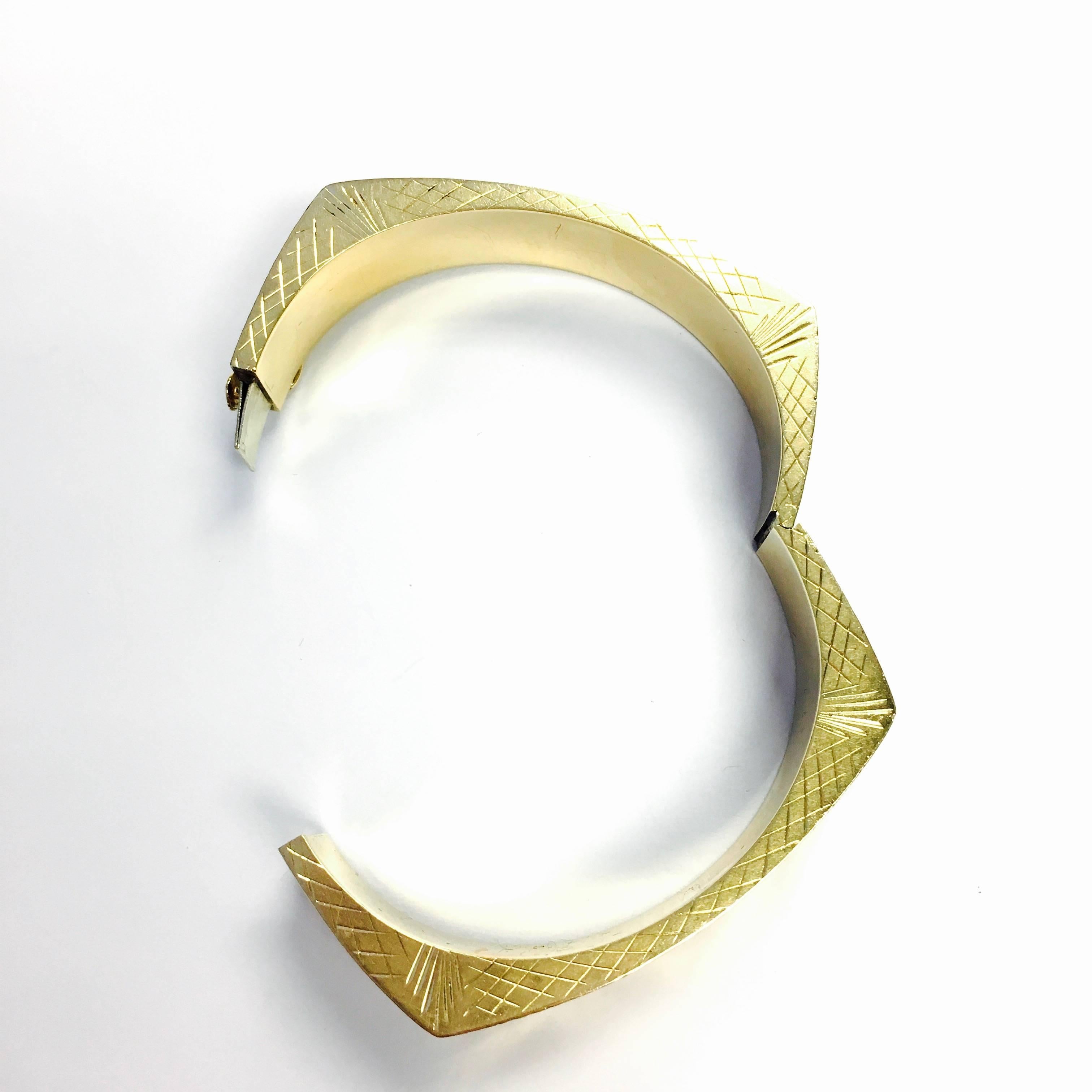 14K yellow gold square, hollow bangle bracelet with laser cut finish. 
Measurements:
Width: approx. 1/2 