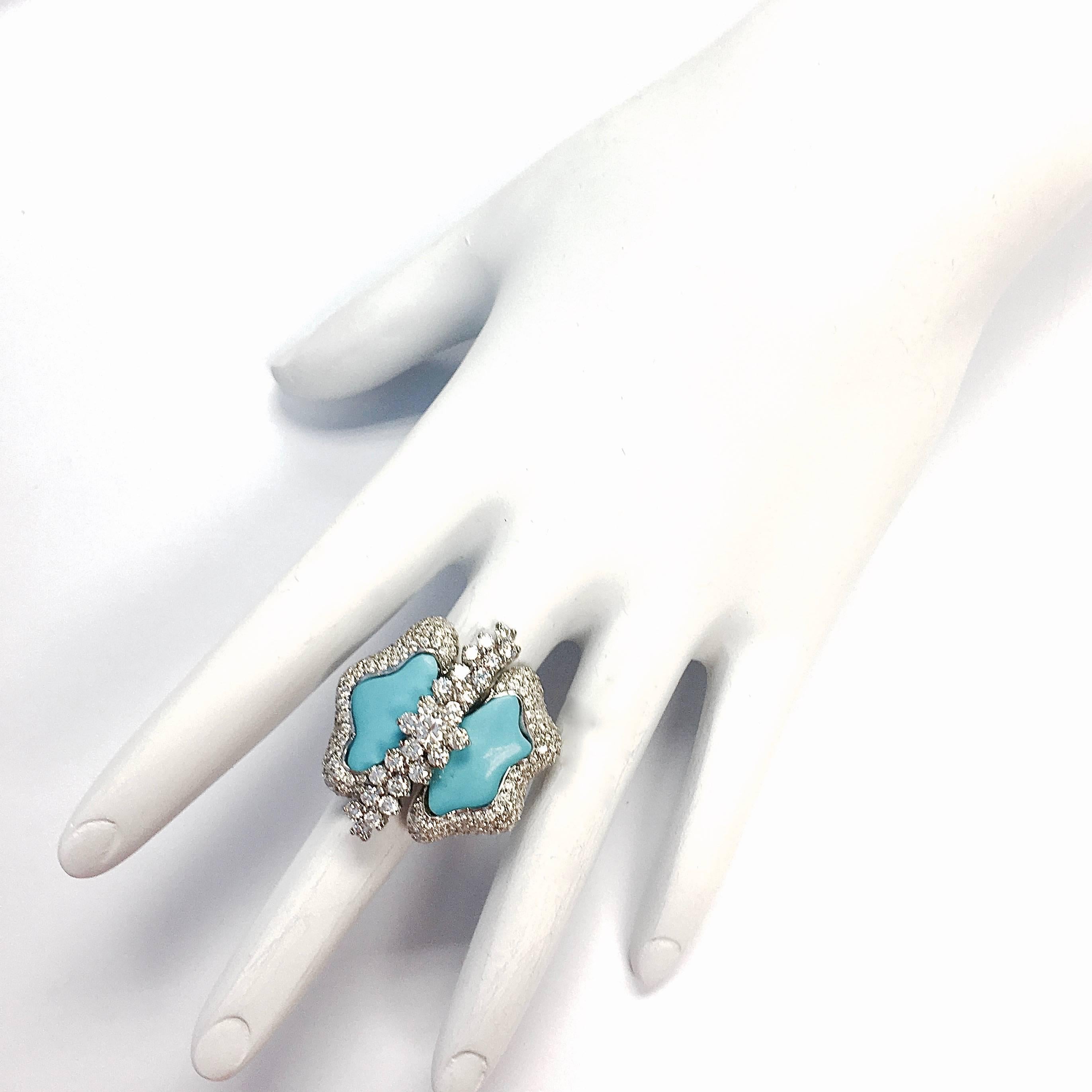 Truly unique 18K white gold ring, featuring a free form turquoise set within a bezel of pave set diamonds, divided by an articulating ribbon of diamonds. 
Approximate total diamond weight: 3.50 ct  Color: F-G, Clarity: VS1-VS2
The front measures: 30