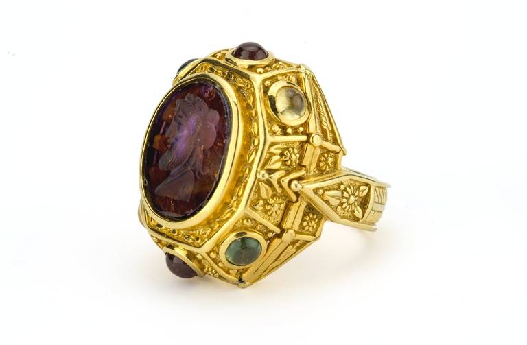 This hand-carved modern Amethyst intaglio is set with 3.40 carats of multi-colored Sapphire cabochons and 18K Yellow Gold, flash finished with 24K for a luxurious saturation of color. Reminiscent of ancient Etruscan design, this stunning and