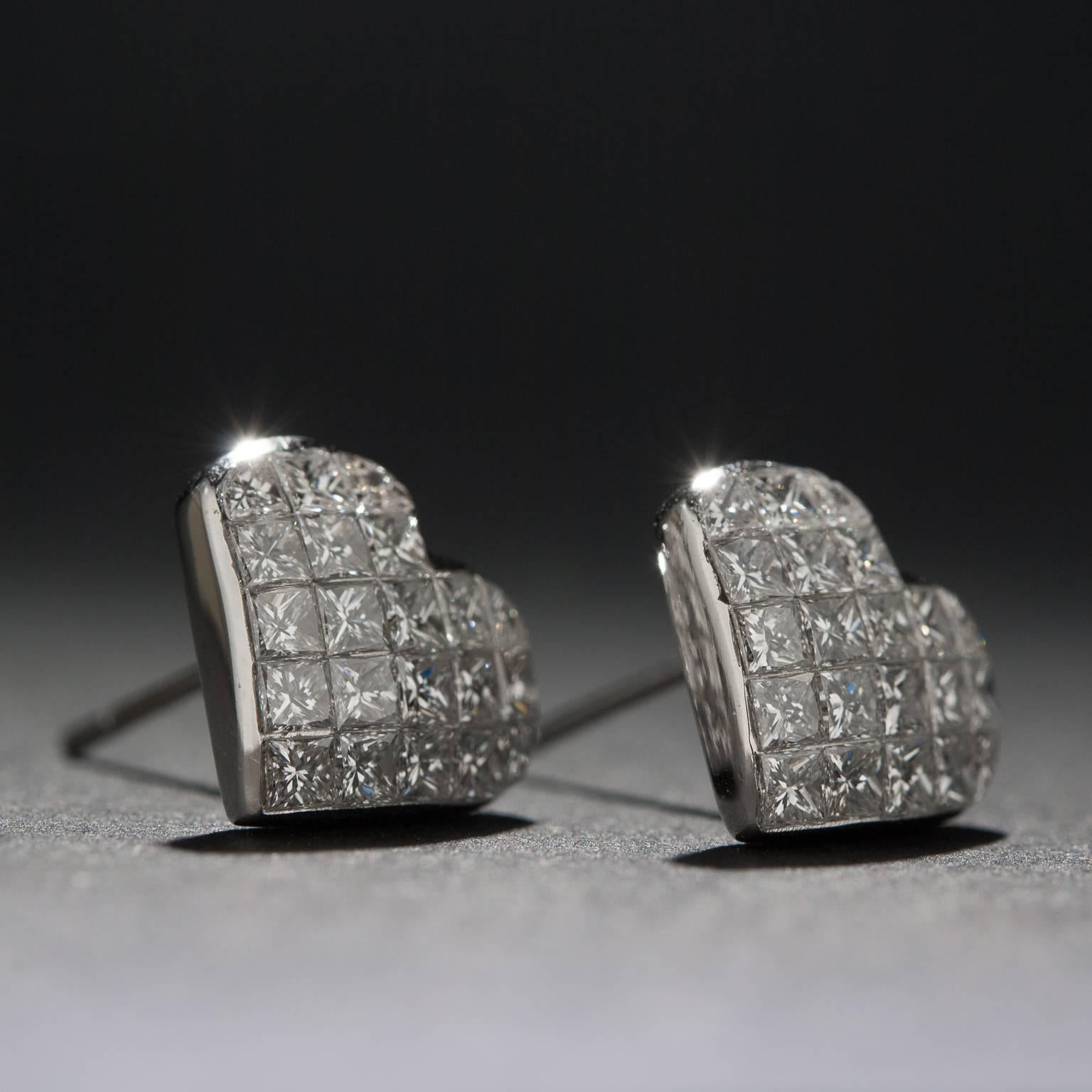 This lovely pair of diamond stud earrings features 42 invisible-set princess cut diamonds for 1.50 total carats. This piece is crafted in 18k white gold.
