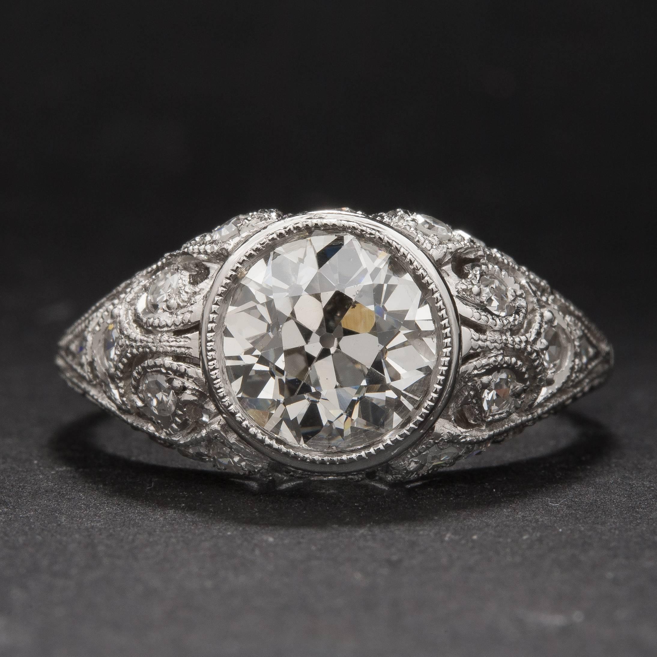A lovely 1.52 carat diamond sits at the center of this intricately designed Art Deco style platinum mounting. The center diamond is estimated I color, VS2 clarity and it is accented by .37 total carats of side diamonds. This ring is currently size