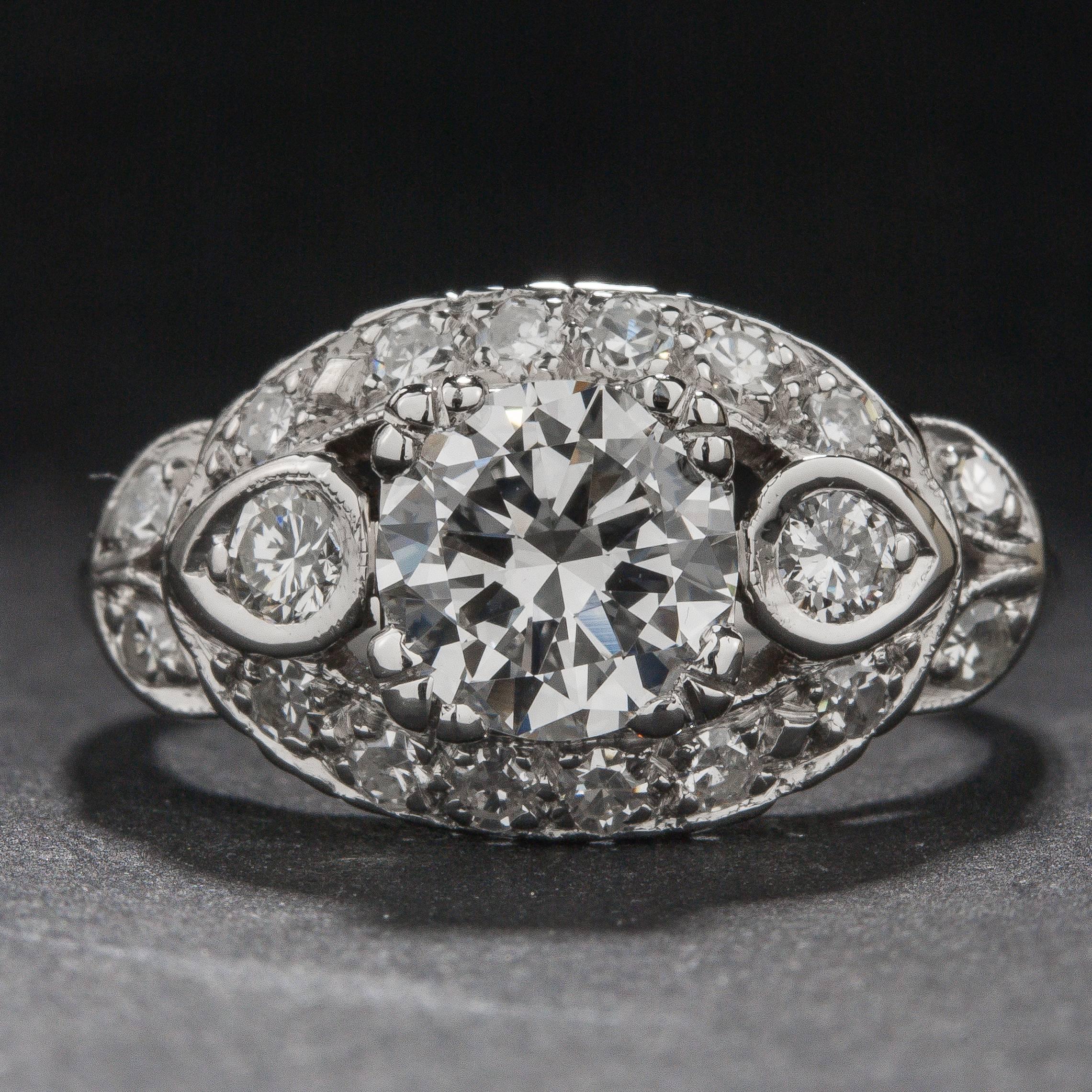 This stunning Art Deco style ring features a .90 carat center diamond and 18 side diamonds for a total of .22 carats. The intricate mounting has been crafted in platinum and the ring is currently size 6.5.