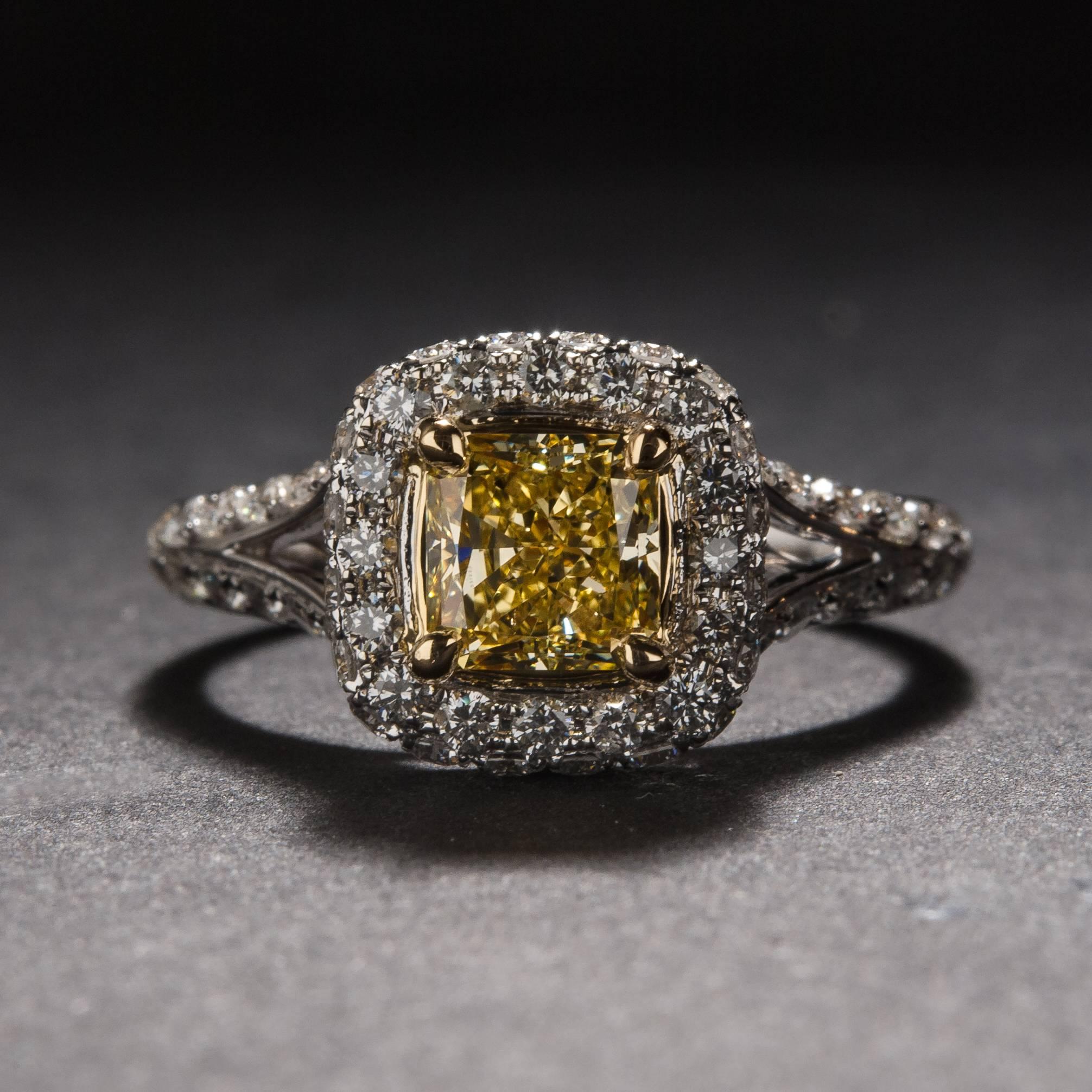 A stunning 1.00 carat fancy yellow diamond mounted in a beautiful split-shank setting with .87 total carats of white accent diamonds. The mounting is crafted in 18k white gold and it is currently size 7.