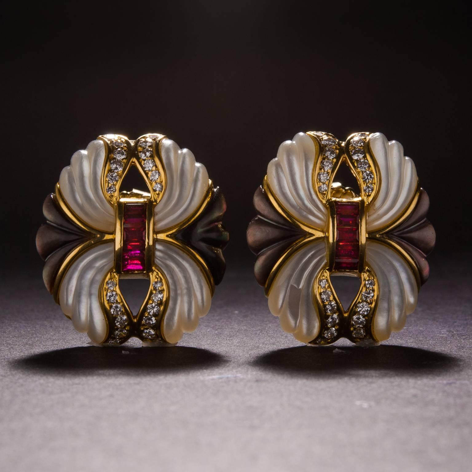 A lovely pair of earrings with carved white and black mother of pearl, 1.00 total carats of rubies, and .50 total carats of diamonds. These earrings feature a post style back and are made in 18k yellow gold. 