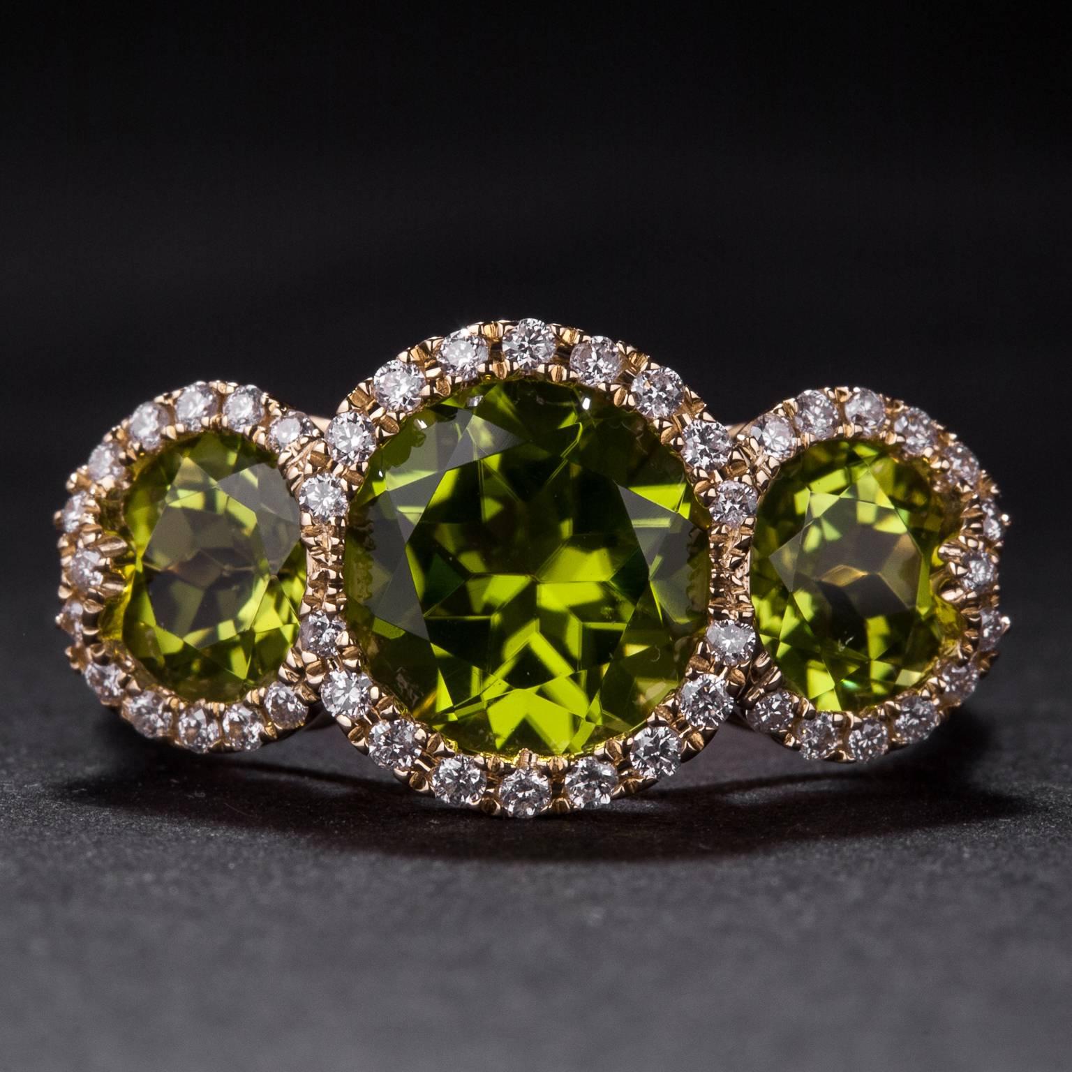 This stunning ring features 3 peridot for a total of 4.20 carats as well as .25 total carats of diamonds. It is crafted in 18k yellow gold and is currently size 7.

This ring may be sized to fit.