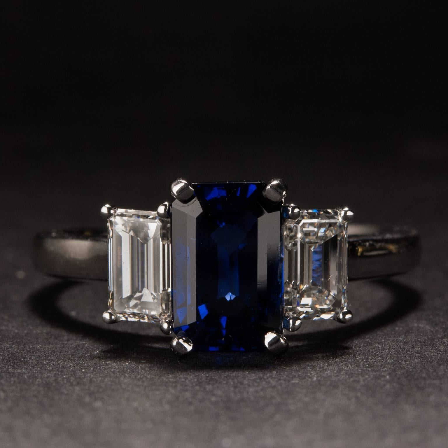 This stunning ring features an 1.37 carat center sapphire which is accent by two bright white emerald cut diamonds weighing a combined total of .70 carats. The mounting is crafted in 18k white gold and it is currently size 6.25.

This ring may be