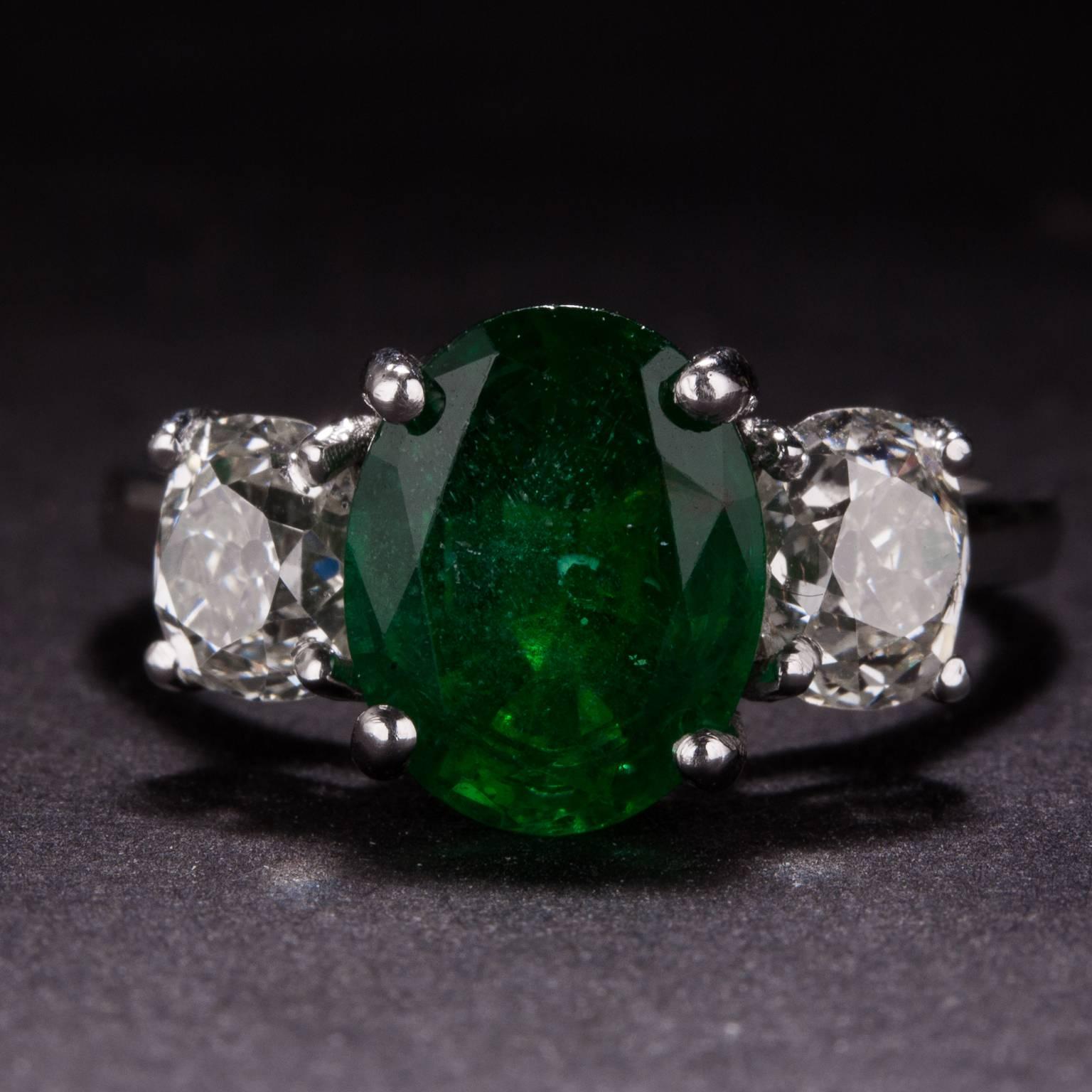 This ring features a beautiful 2.12 carat oval cut center emerald and 2 side diamonds for a total of 1.55 carats. The mounting is crafted in platinum and it is currently size 6.25.