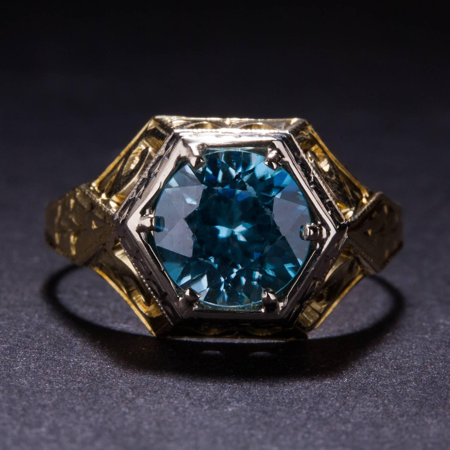 This extraordinary ring features a 2.00 carat blue zircon set in a 10k two-tone gold mounting. This piece has stunning hand-engraved details and is currently size 6.5.