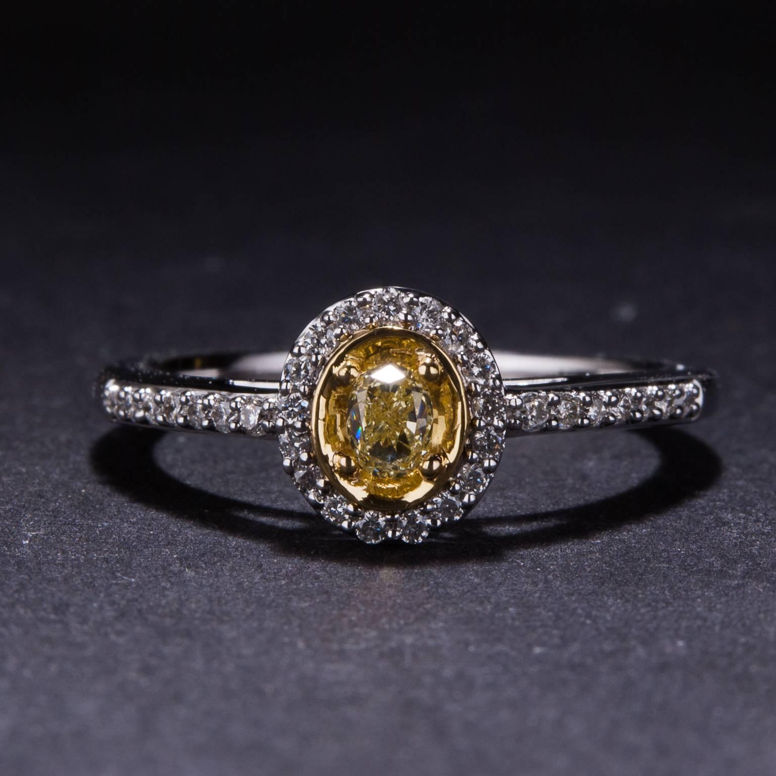 This lovely ring has been crafted in 14k white and yellow gold and features a total of .38ctw in white diamonds and fancy yellow diamonds. This piece is currently size 7 and may be sized to fit. 