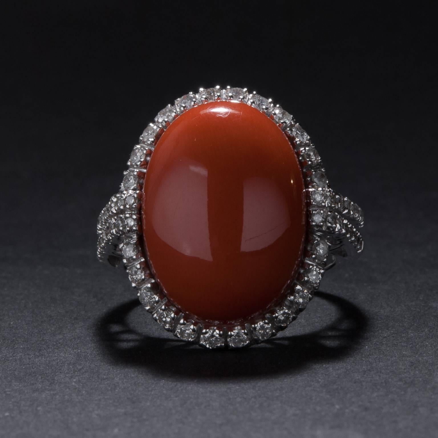 A stunning red coral ring with 52 accent diamonds weighing a total of .88 carats. The mounting is crafted in 18k white gold and it is currently size 6.75.