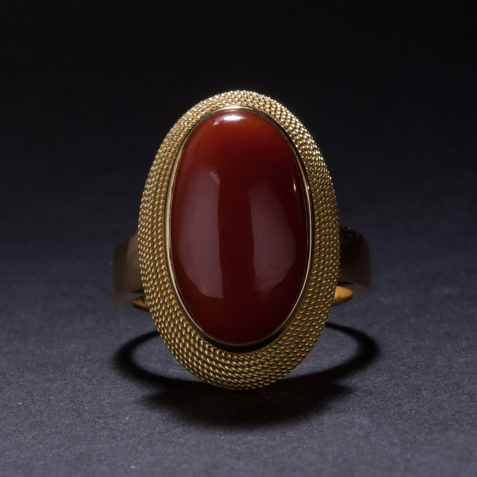 This lovely Italian Red Coral ring was crafted in Italy. The elegant 18k yellow gold mounting features woven gold detailing and is currently sized at 7.

This ring may be size to fit.